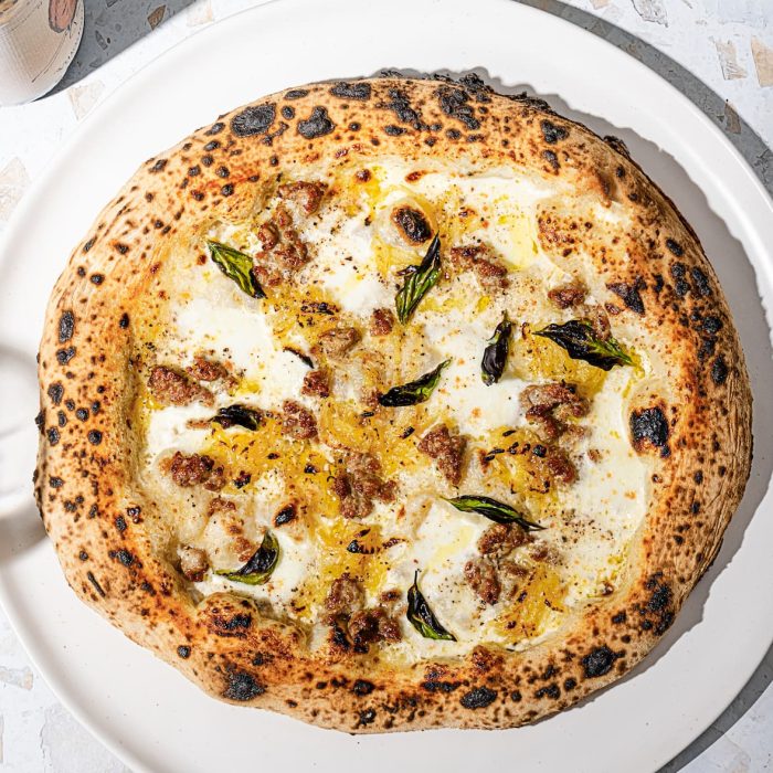 Pizza blanche avec saucisses italiennes et oignons caramélisés