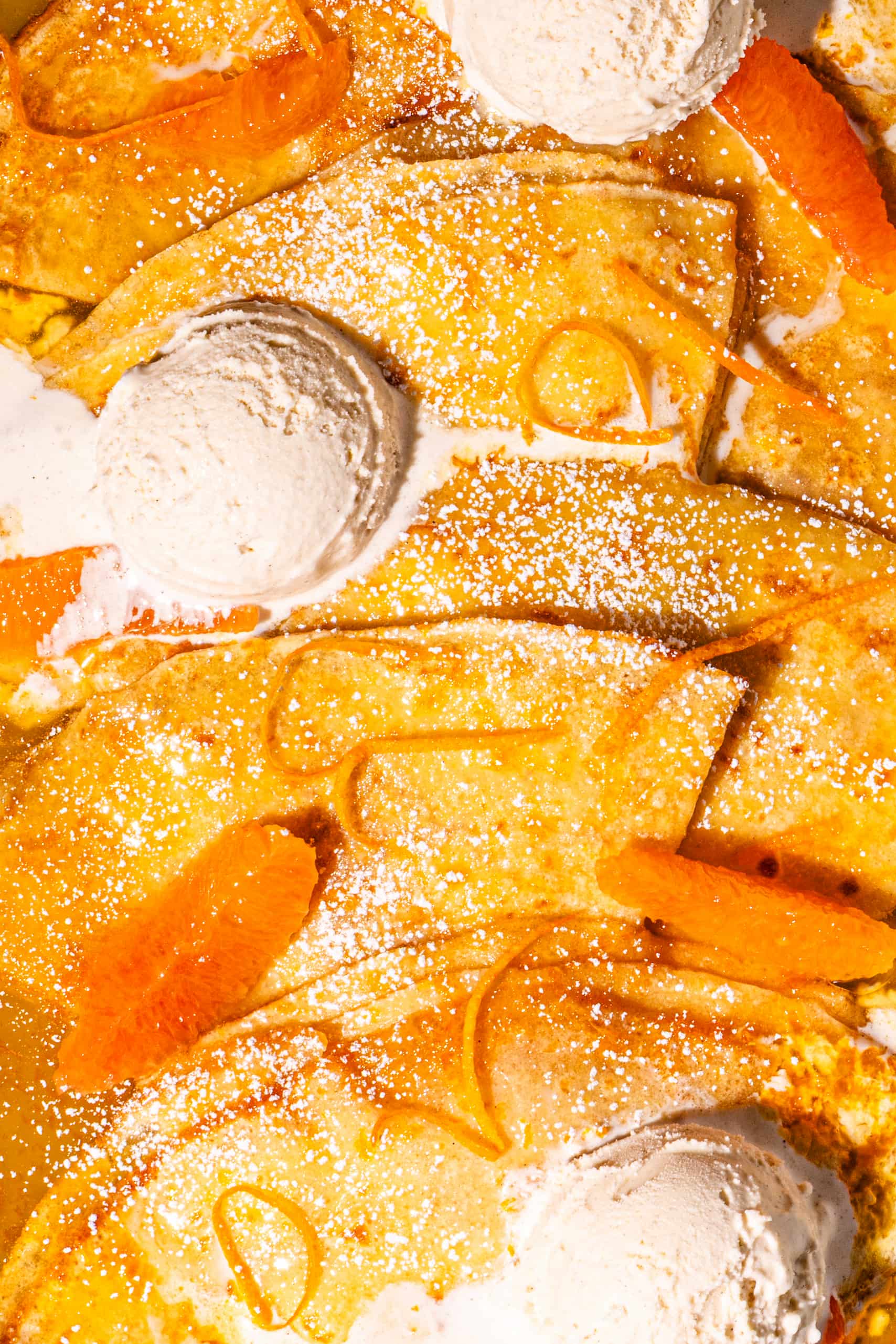Crêpes suzette flambées avec crème glacée à la vanille et suprêmes d'orange