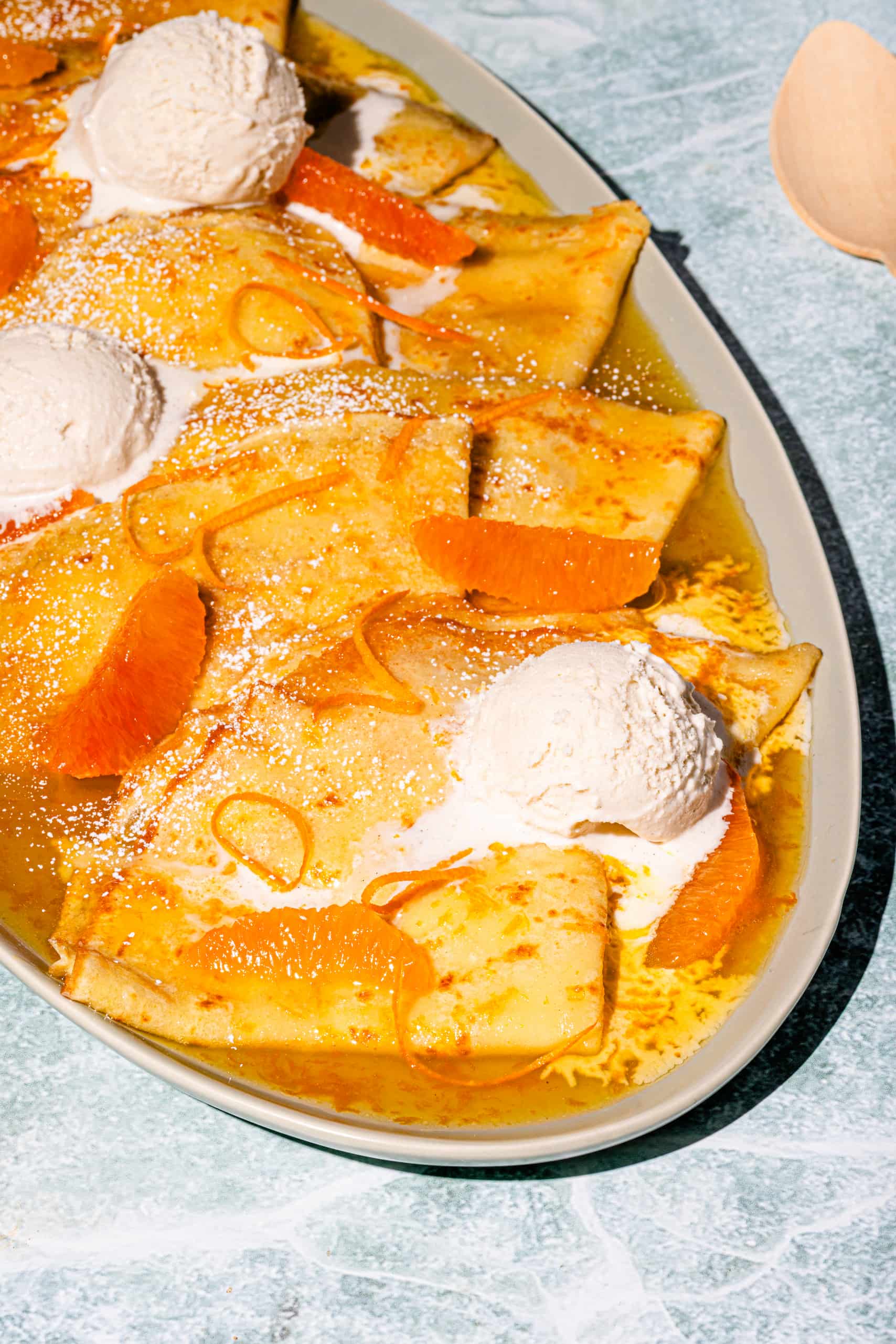 Crêpes suzette flambées avec crème glacée à la vanille et suprêmes d'orange