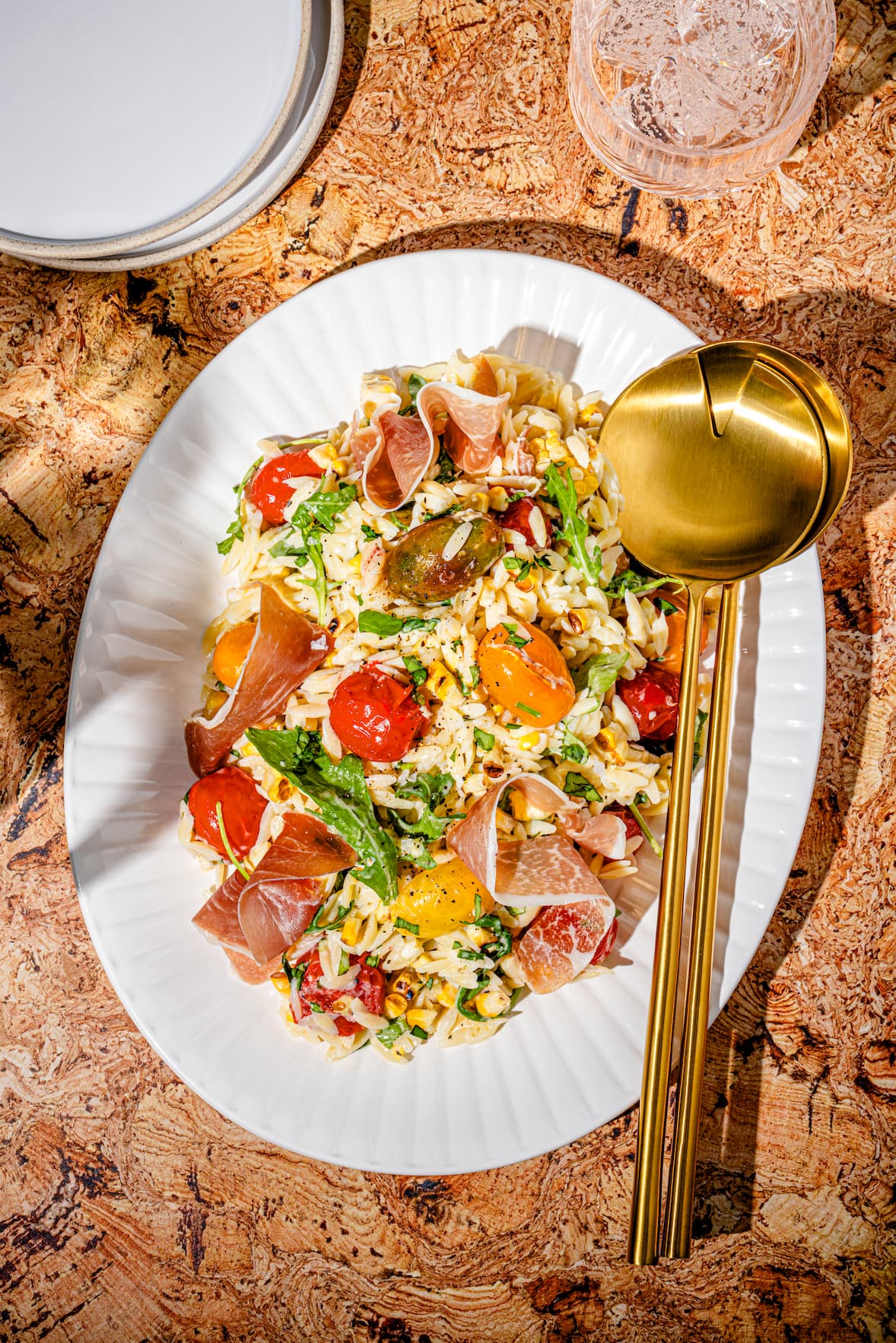 Salade d'orzo froide avec tomates confites, maïs grillé et prosciutto