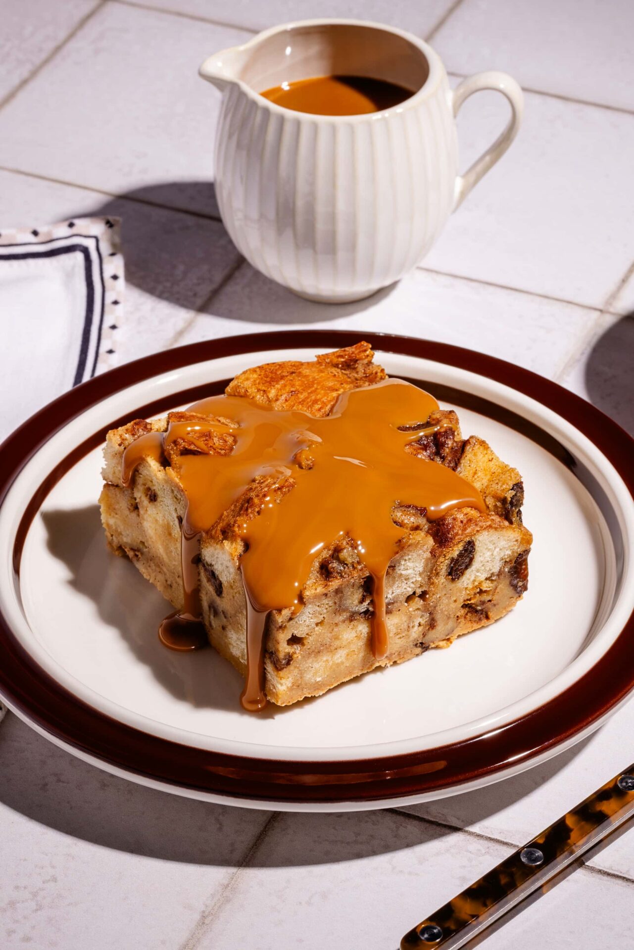 Pouding de pain perdu cannelle et raisins nappé de dulce de leche dans une assiette