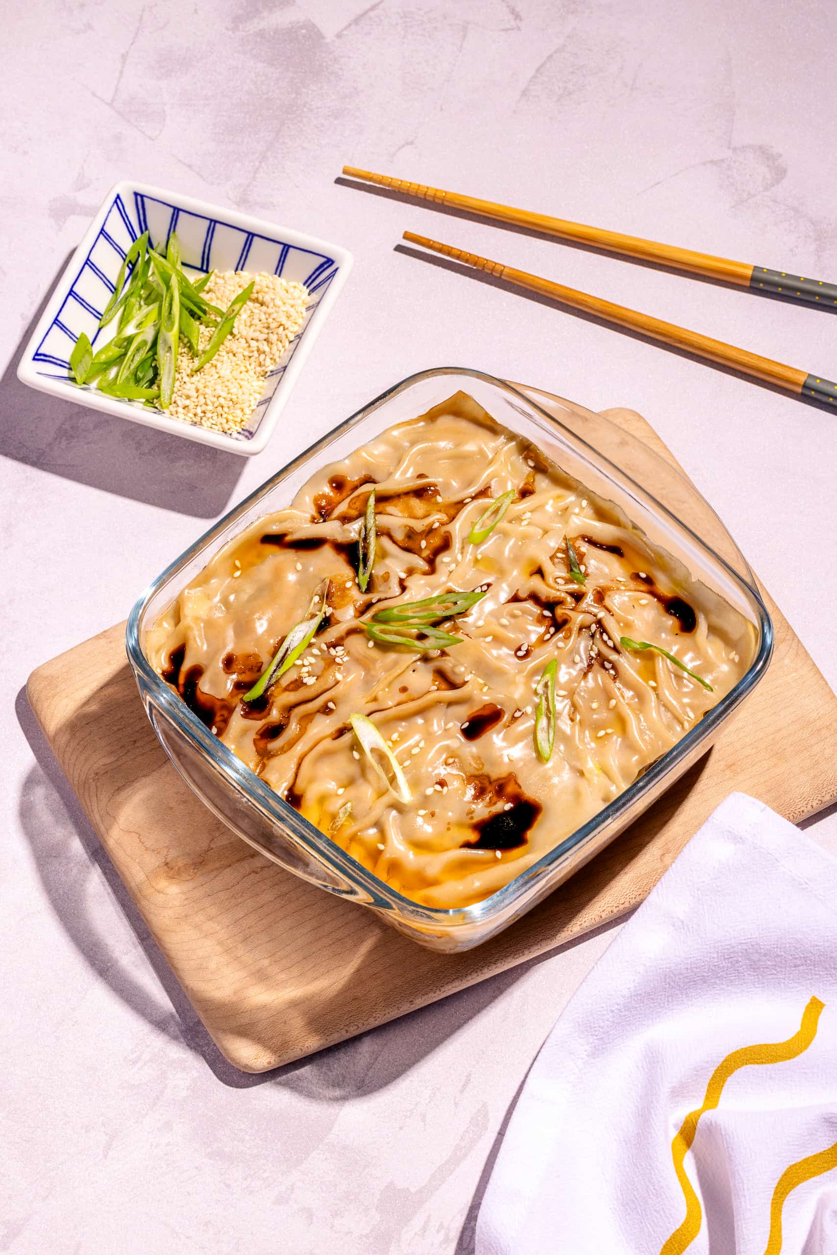 Lasagne dumpling au porc à la vapeur garnie d’oignon vert et sésame