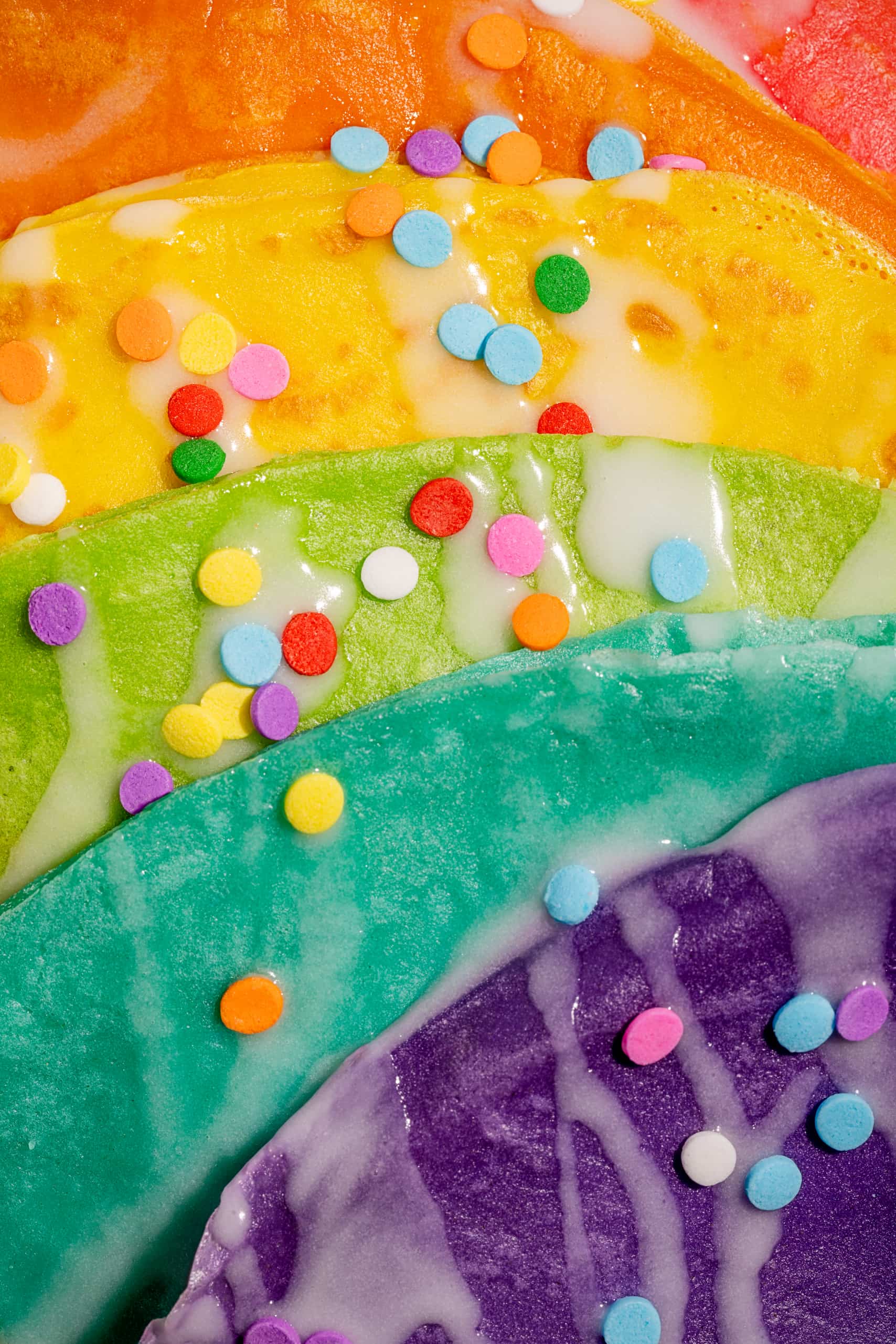 Crêpes colorés étagées dans des assiettes pour célébrer un anniversaire d'enfants