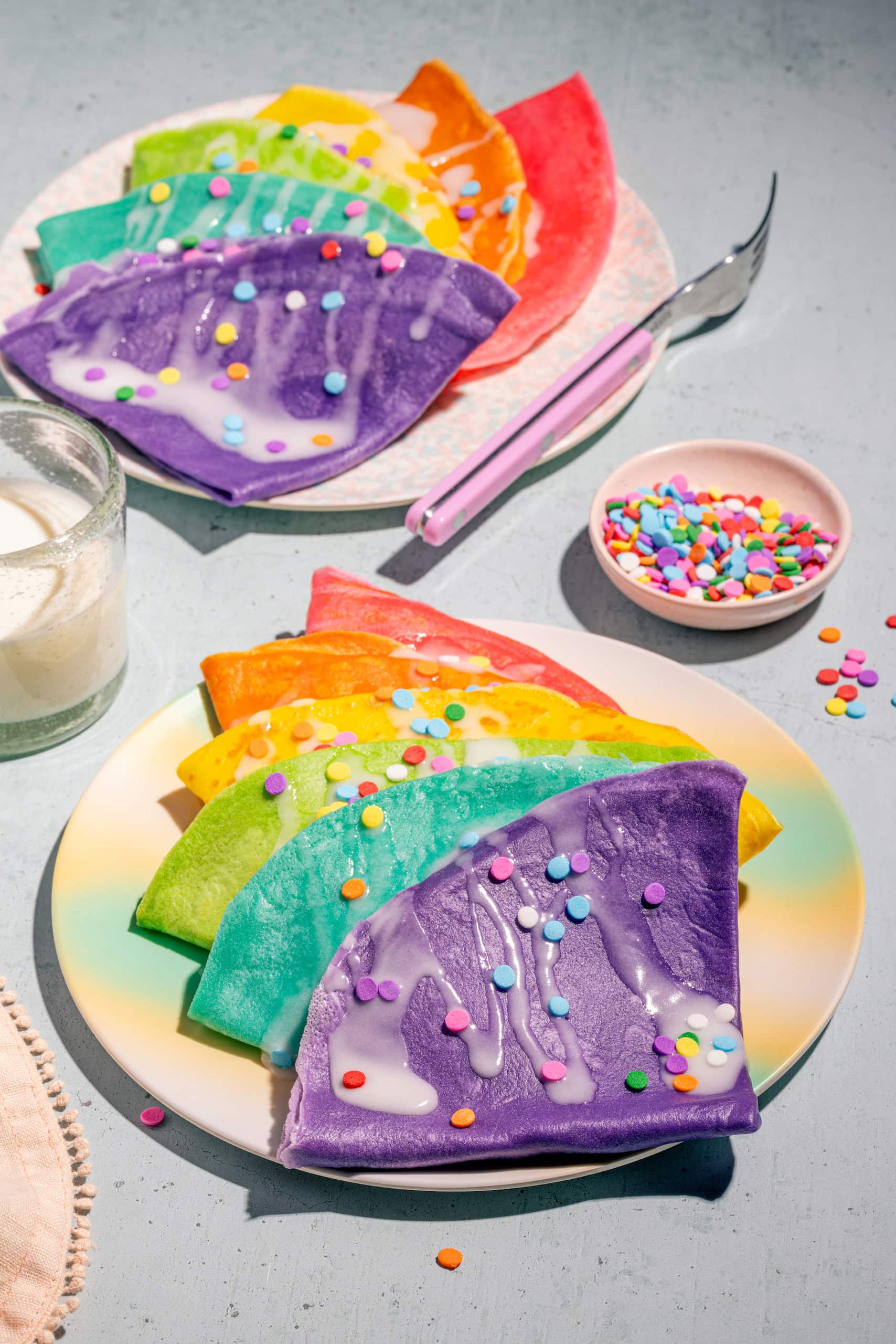 Crêpes colorés étagées dans des assiettes pour célébrer un anniversaire d'enfants