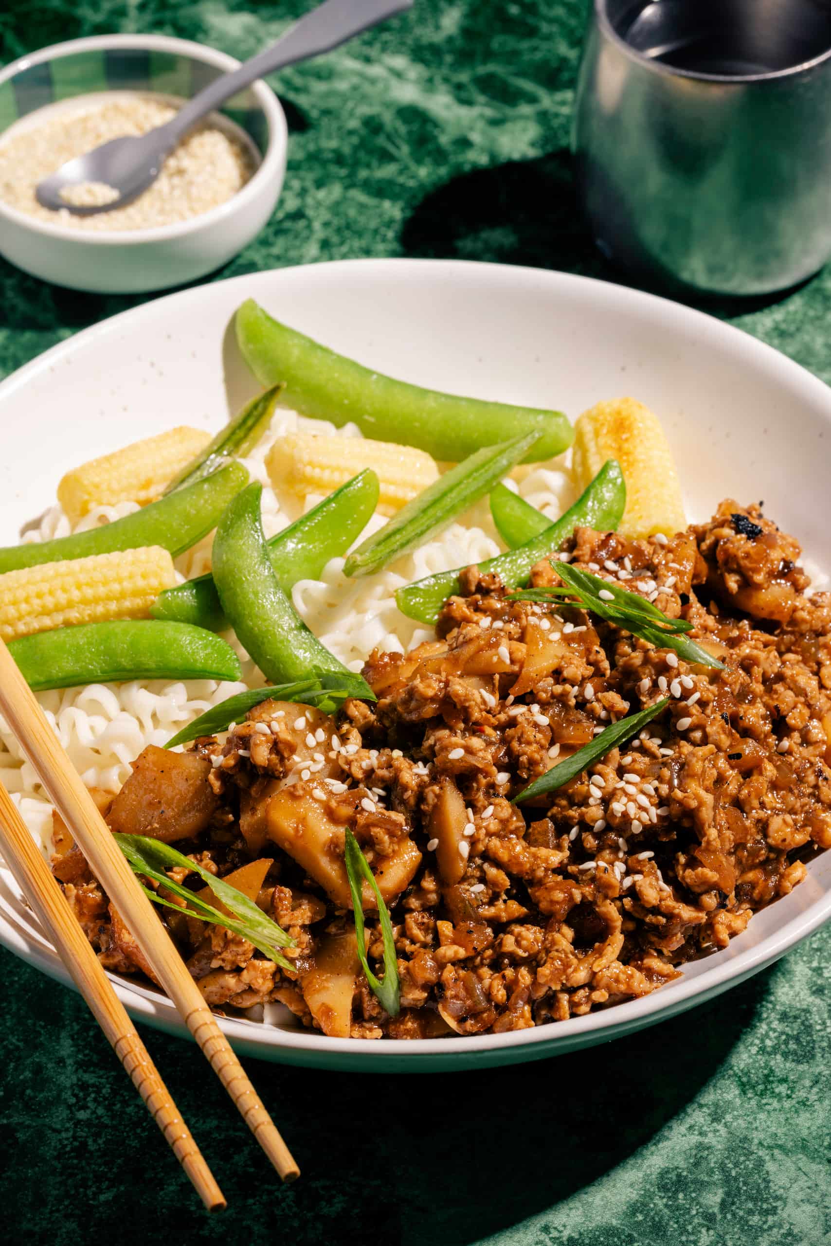 Poulet haché sauce hoisin gingembre et sésame dans un bol avec riz et légumes vapeur