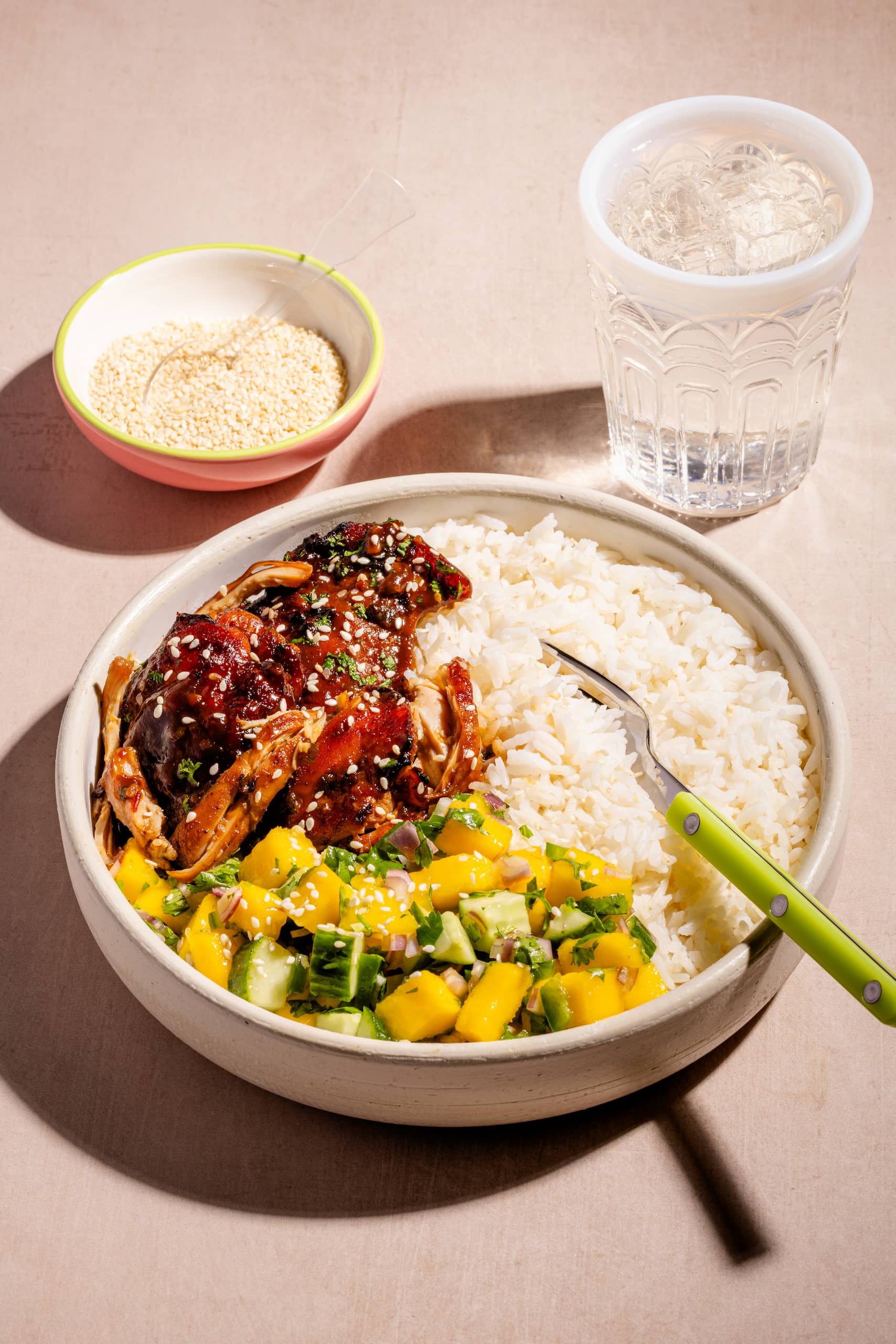 Bol de hauts de cuisses à l'asiatique garni de salsa de mangues et servi sur riz