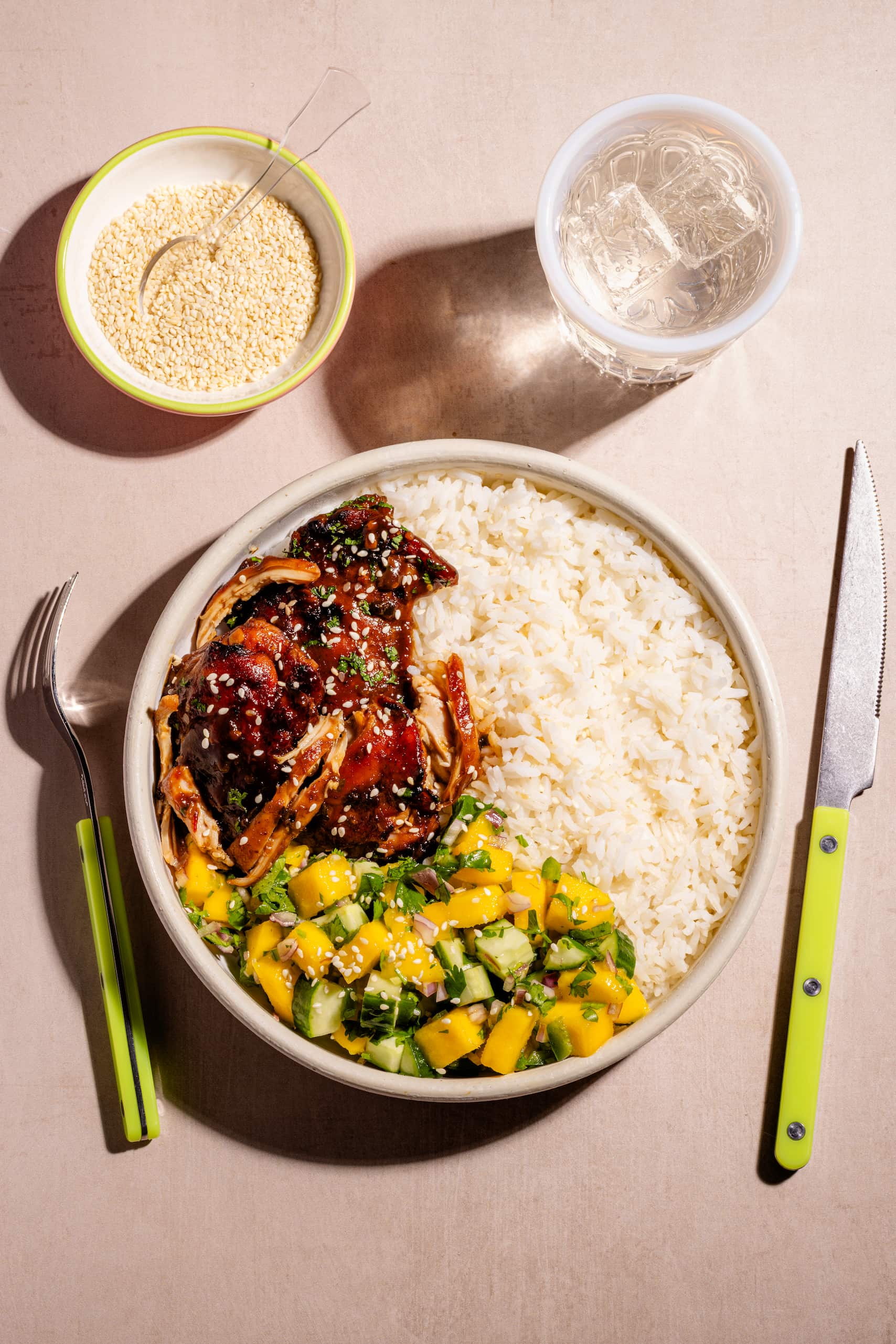Bol de hauts de cuisses à l'asiatique garni de salsa de mangues et servi sur riz