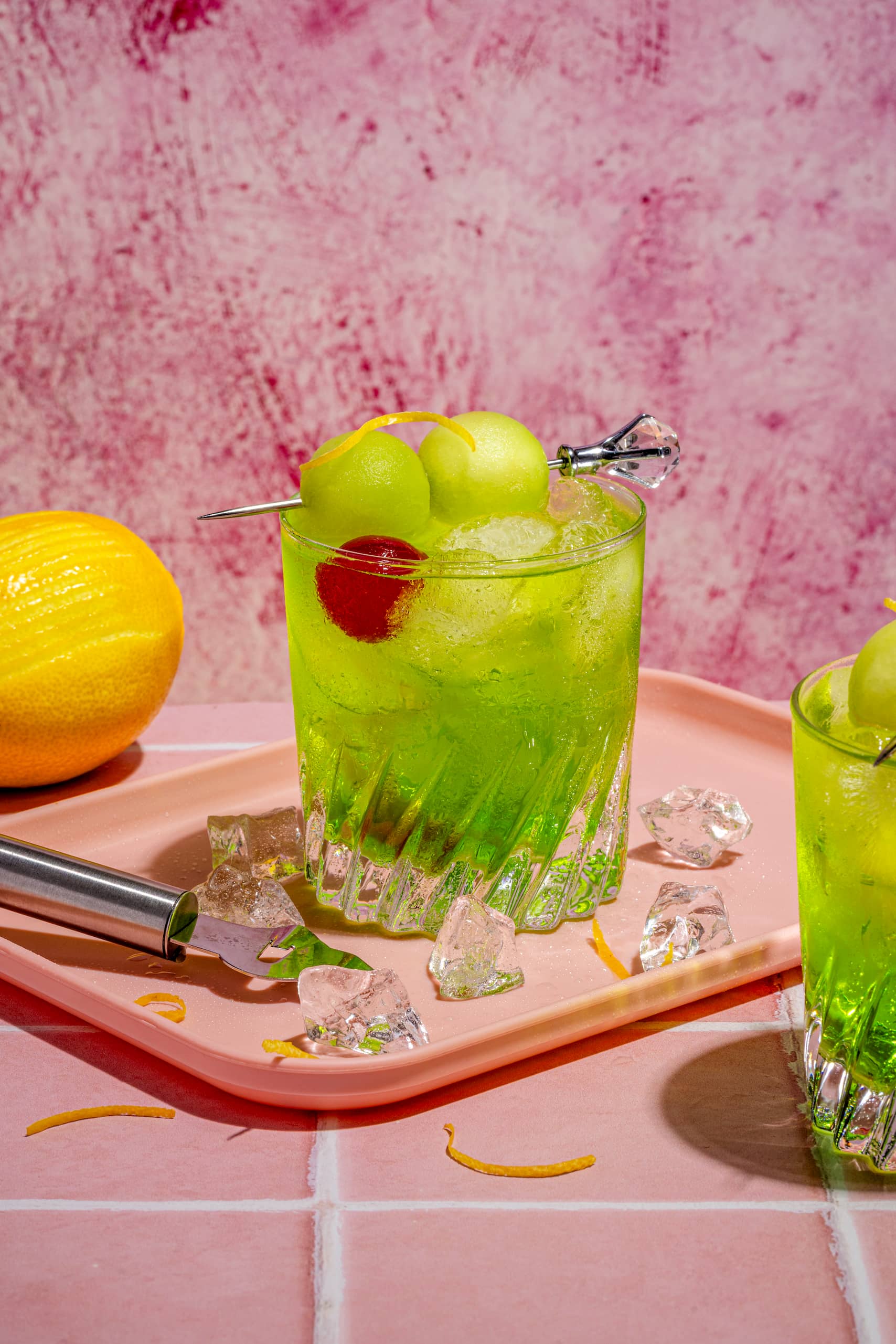 Fizz au Midori servi dans un verre lowball avec cerise au marasquin et zeste de lime
