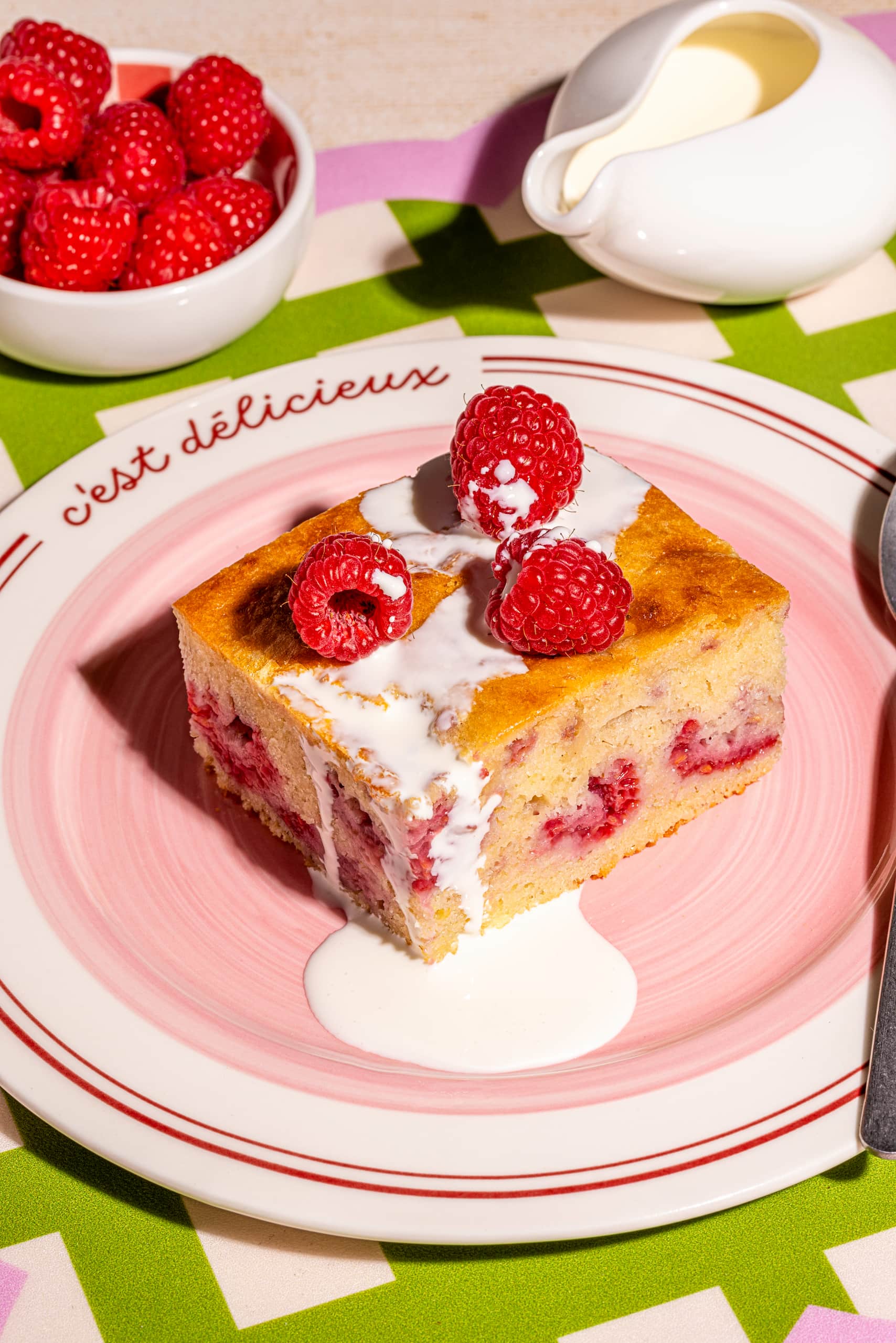 Gâteau aux framboises et au chocolat blanc moelleux coupé en carrés dans un moule