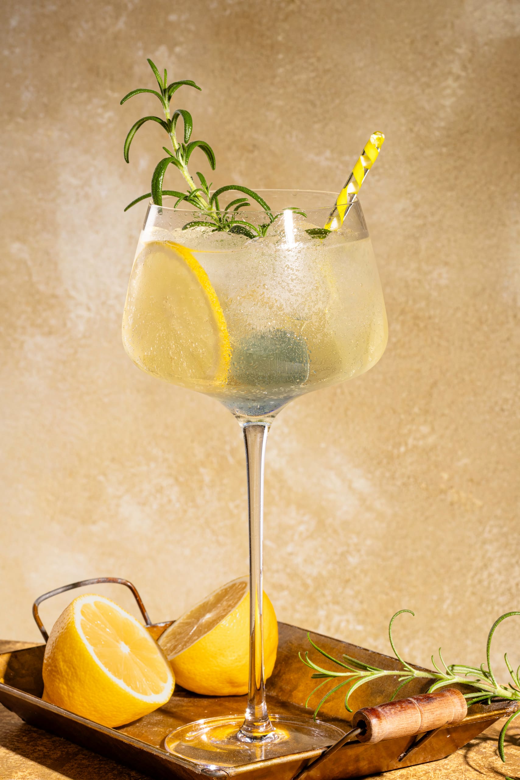 Limoncello Spritz maison dans un grand verre à vin avec tranches de citron et romarin frais