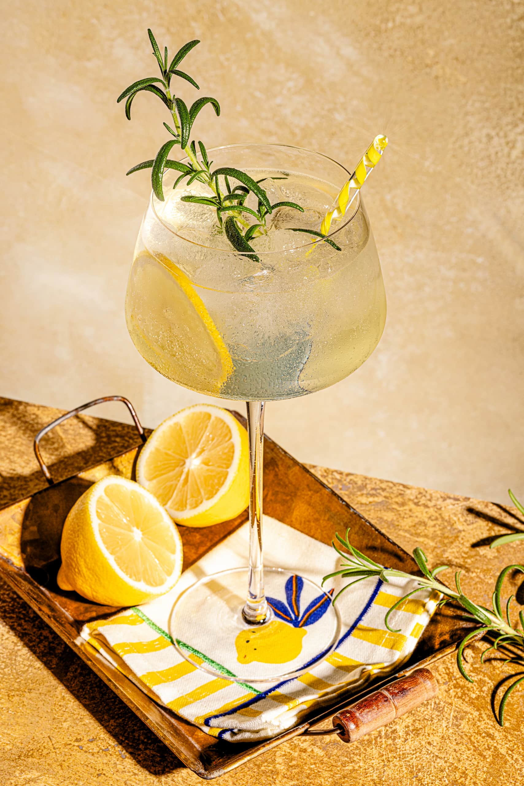 Limoncello Spritz maison dans un grand verre à vin avec tranches de citron et romarin frais