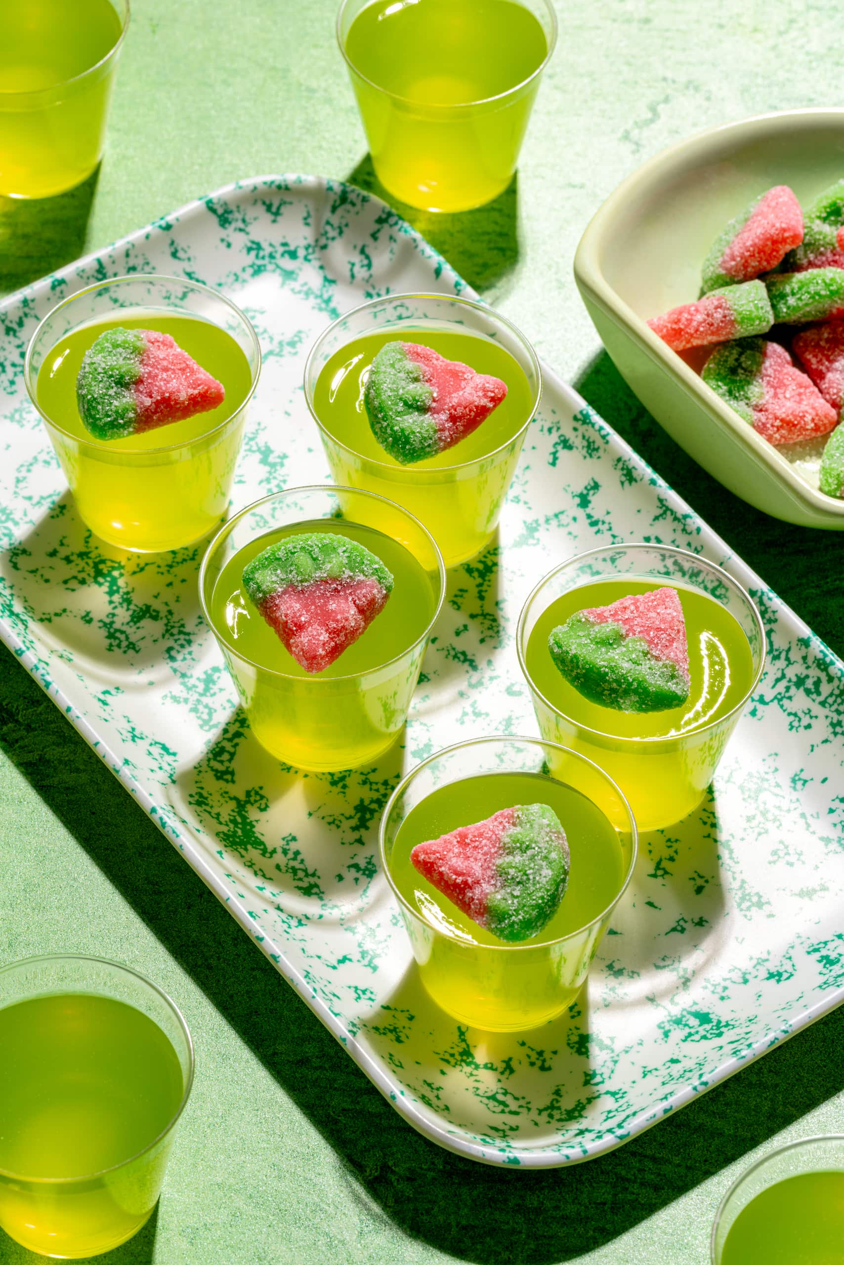 Shots gélifiés au Midori servis dans des verres à shooter avec garniture de bonbons melon d'eau