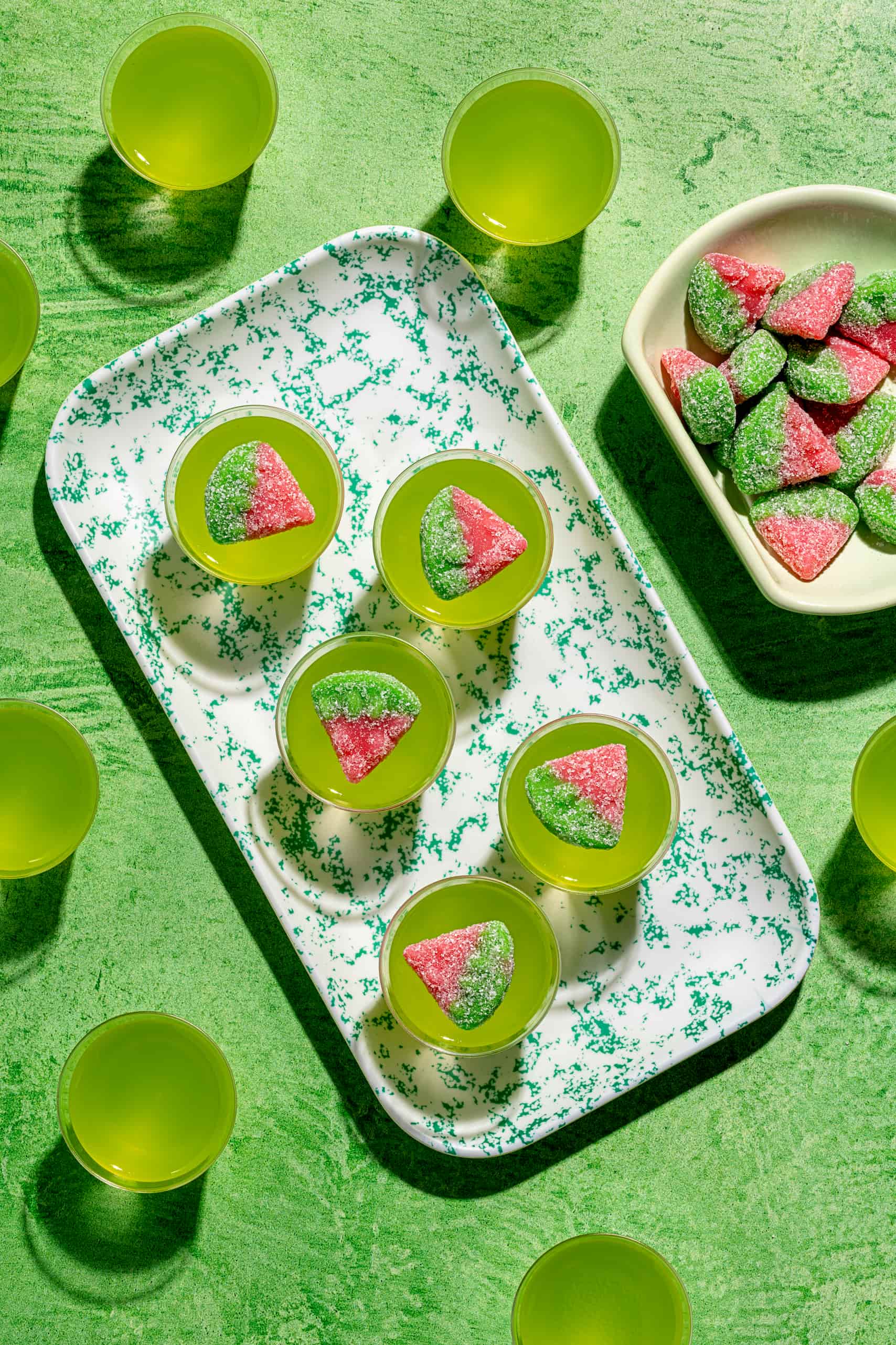 Shots gélifiés au Midori servis dans des verres à shooter avec garniture de bonbons melon d'eau