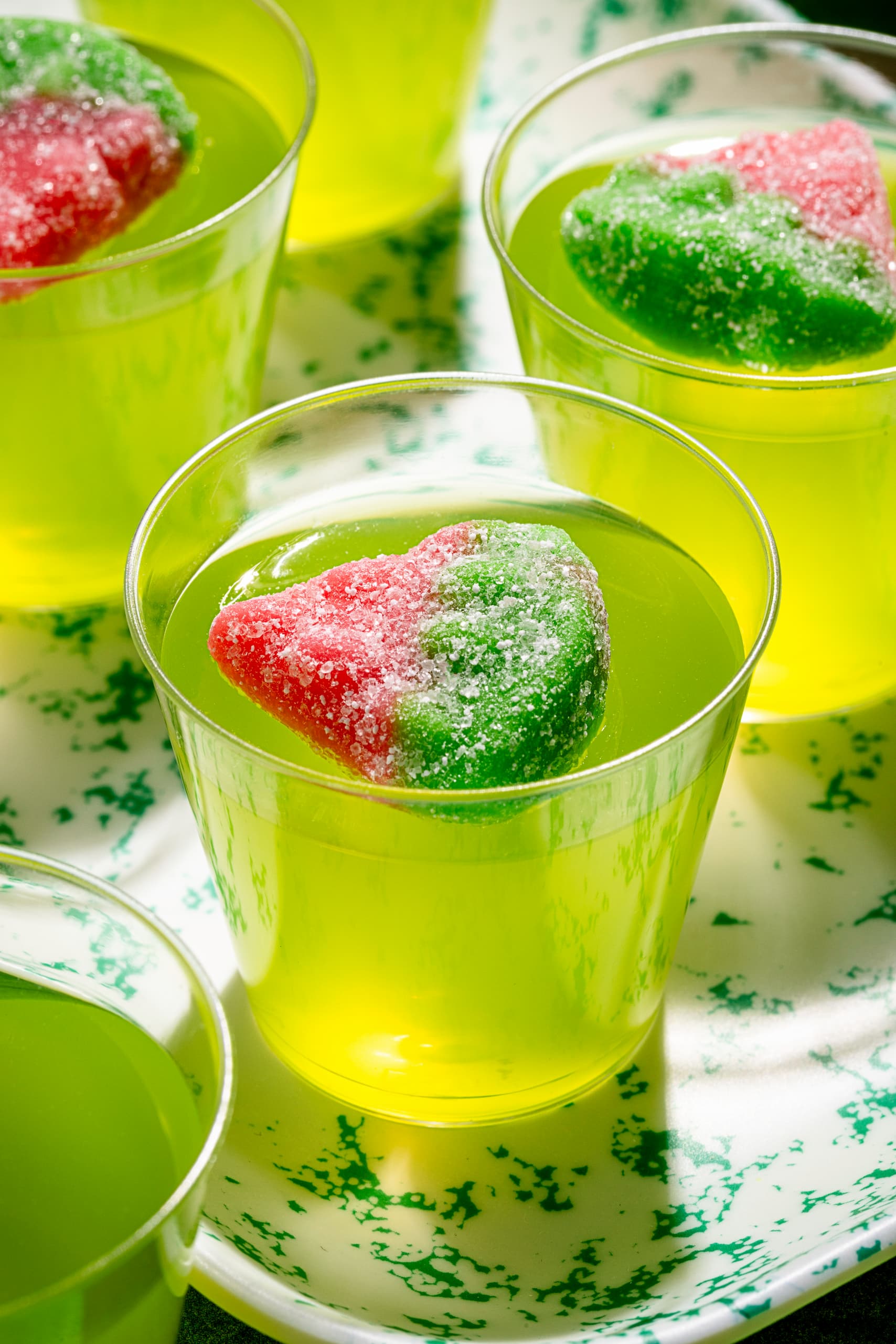 Shots gélifiés au Midori servis dans des verres à shooter avec garniture de bonbons melon d'eau