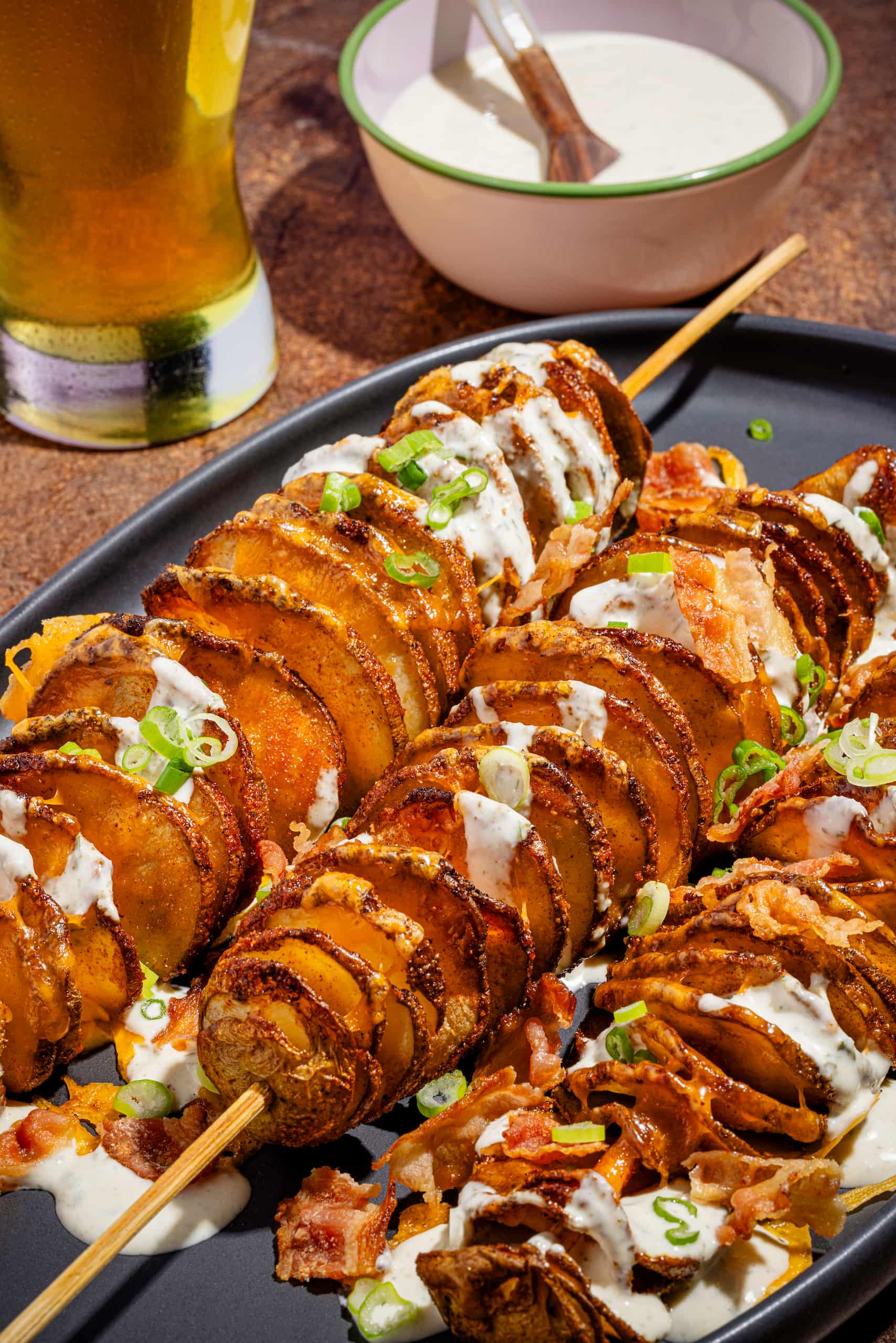 Pommes de terre spirales garnies de cheddar fondant, bacon croustillant et sauce ranch