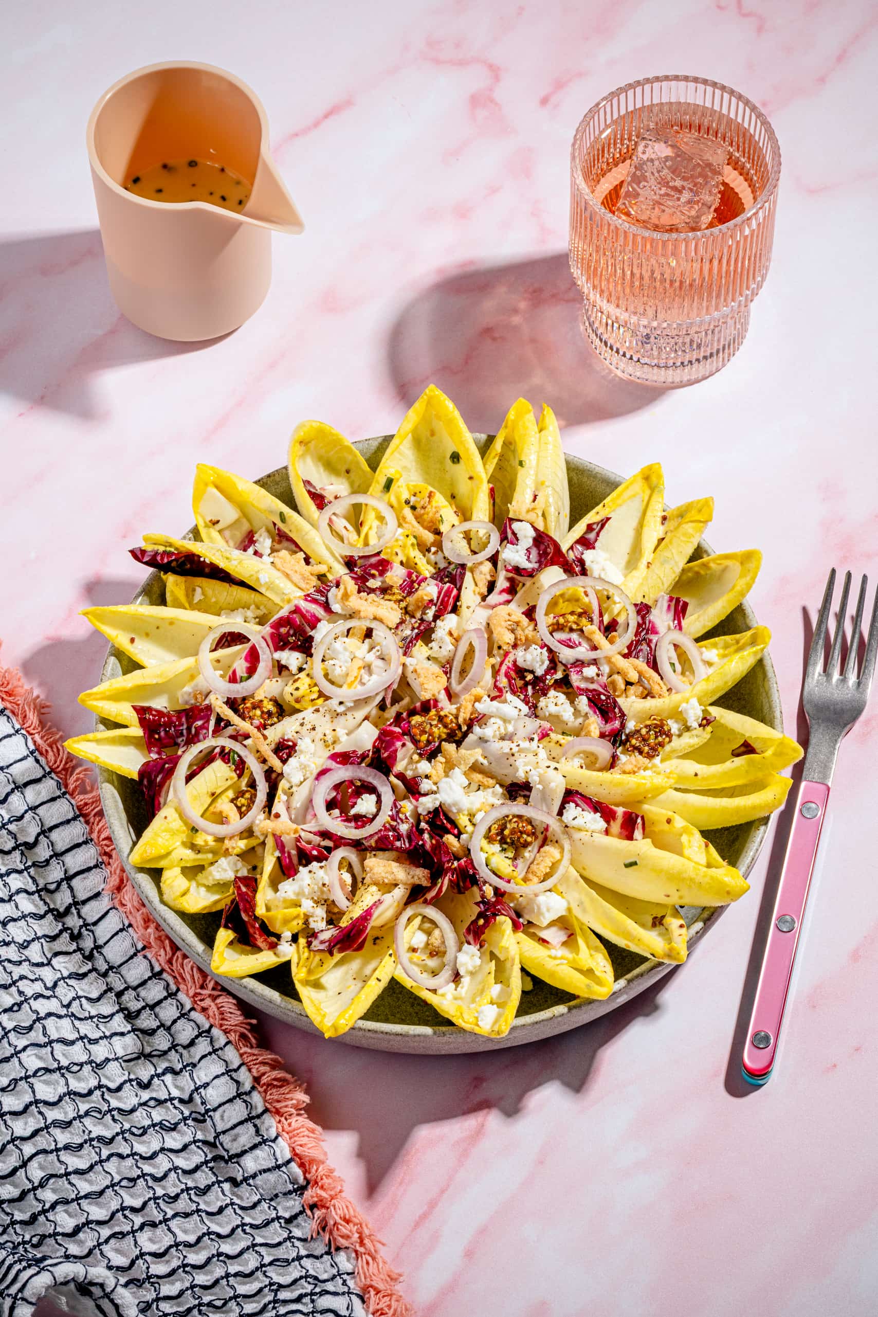 Salade d'endives estivale garnie de feta, d'oignons frits et de vinaigrette à l'érable