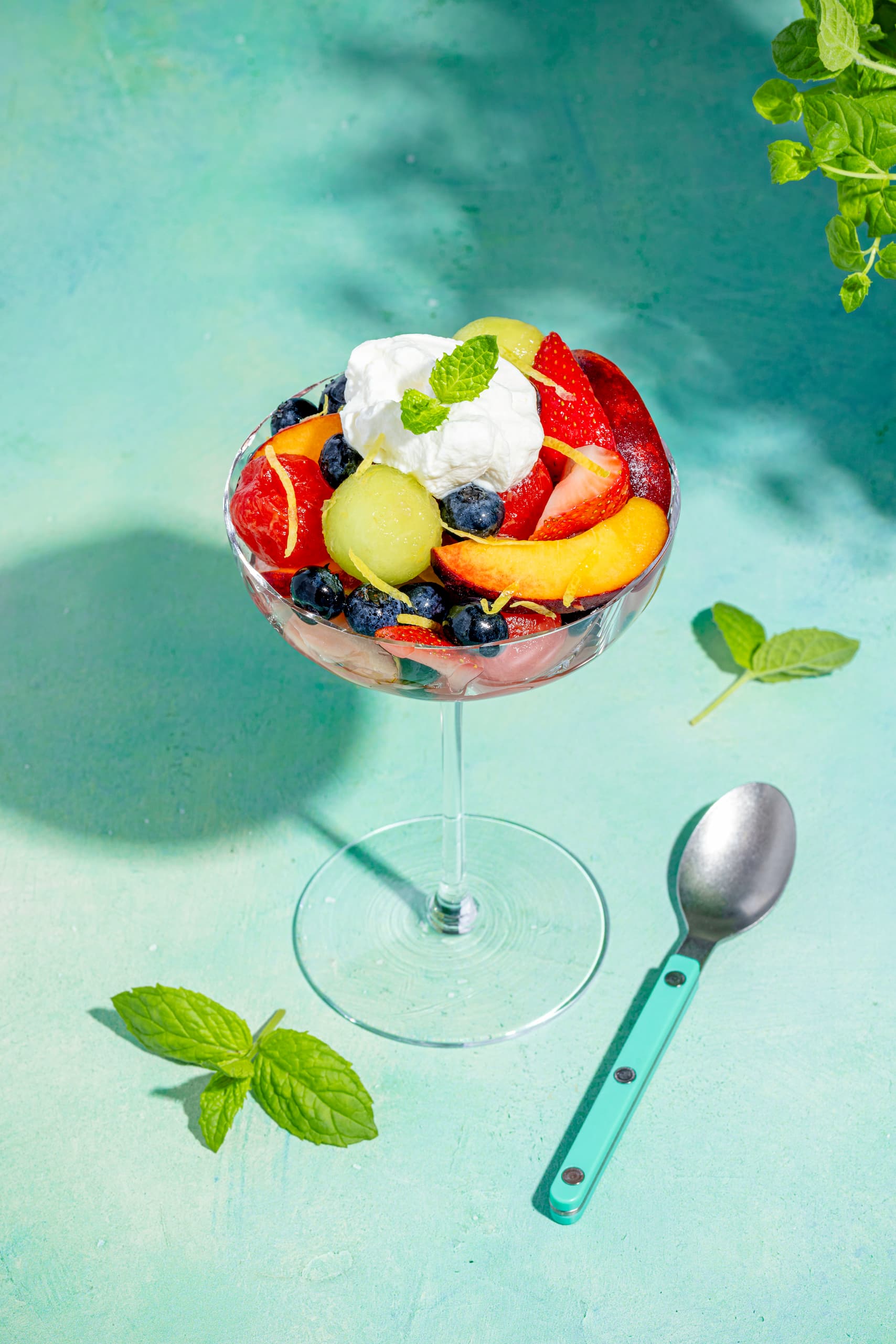 Coupe de fruits au limoncello servie en verrine avec crème fouettée et menthe fraîche