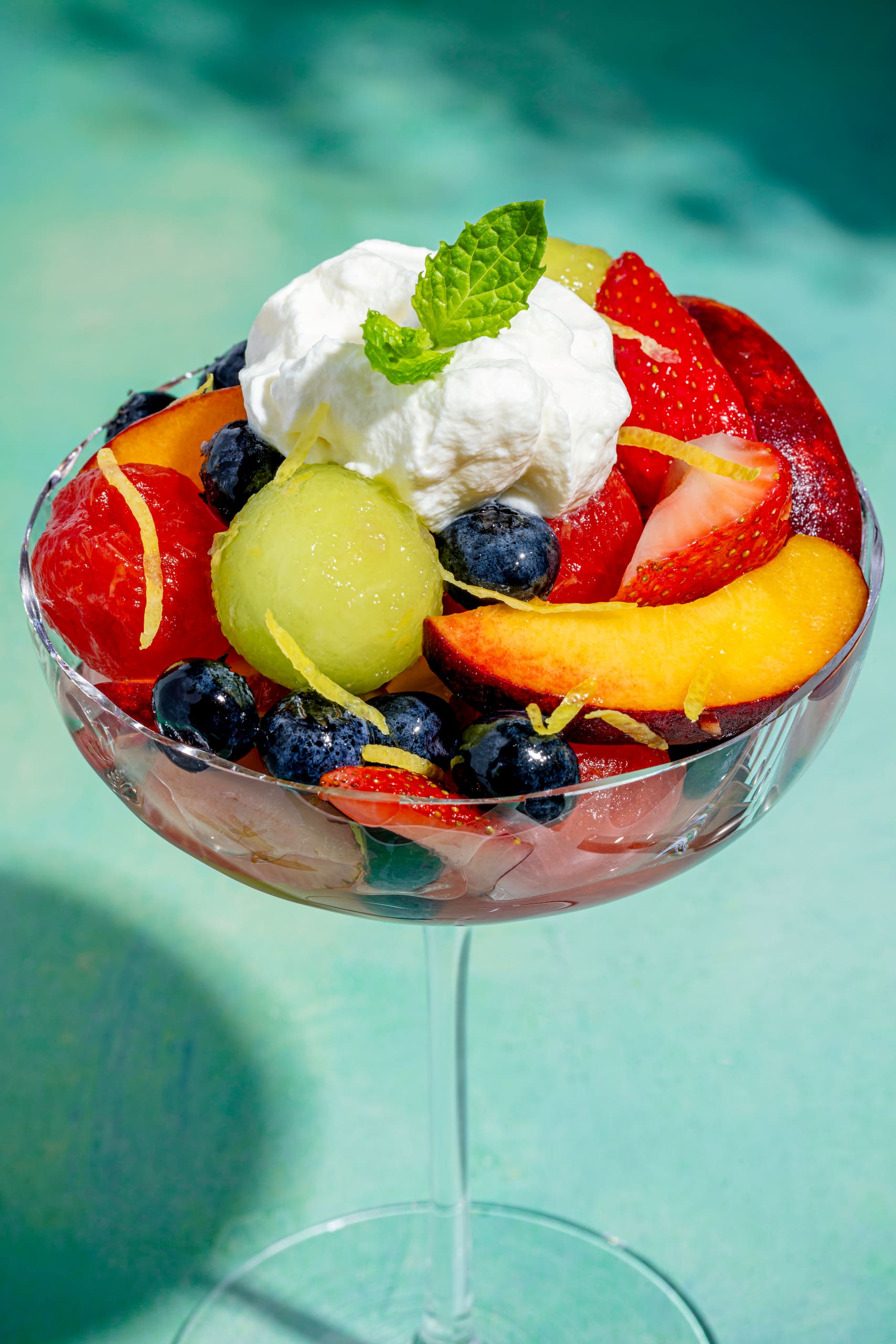 Coupe de fruits au limoncello servie en verrine avec crème fouettée et menthe fraîche