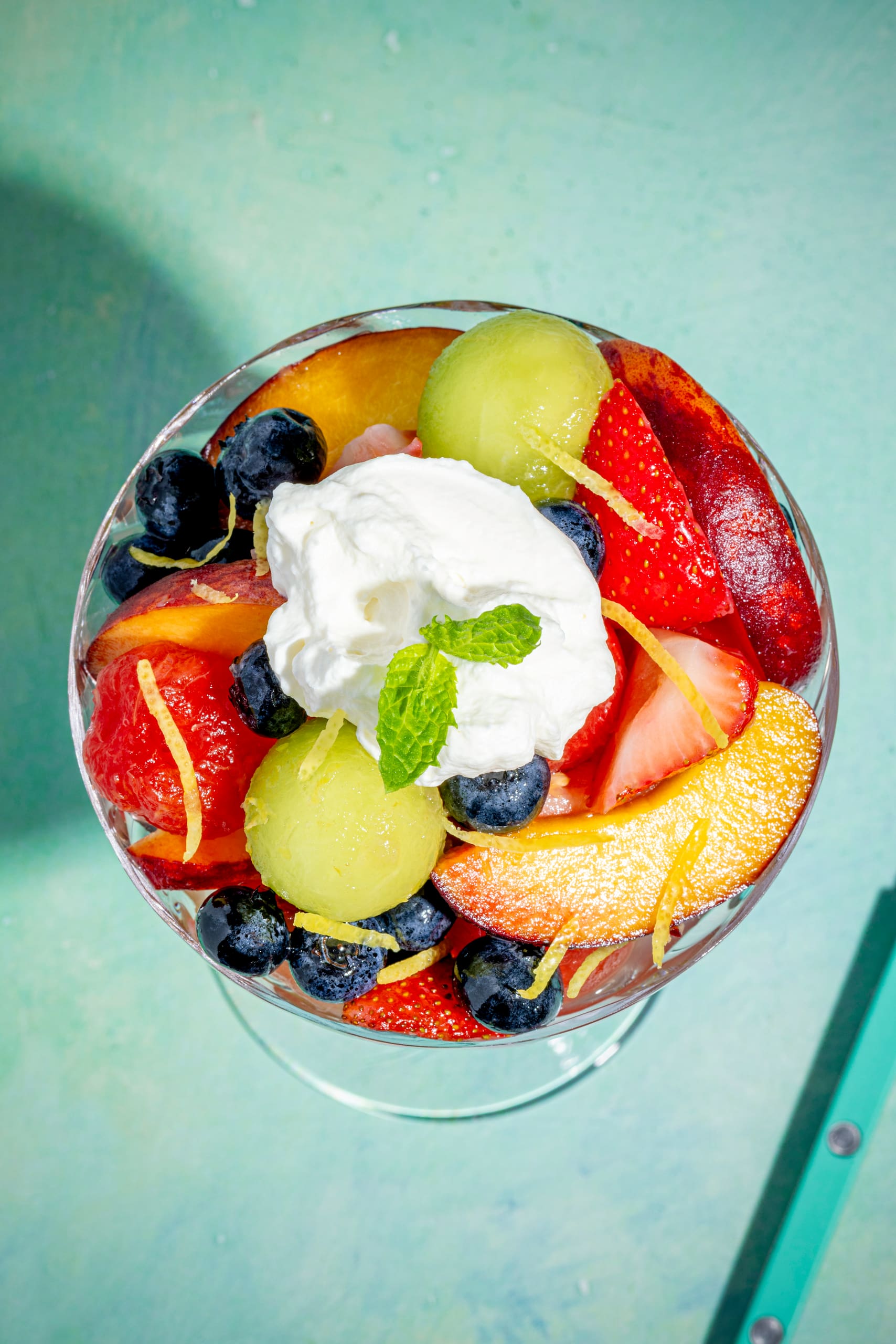 Coupe de fruits au limoncello servie en verrine avec crème fouettée et menthe fraîche