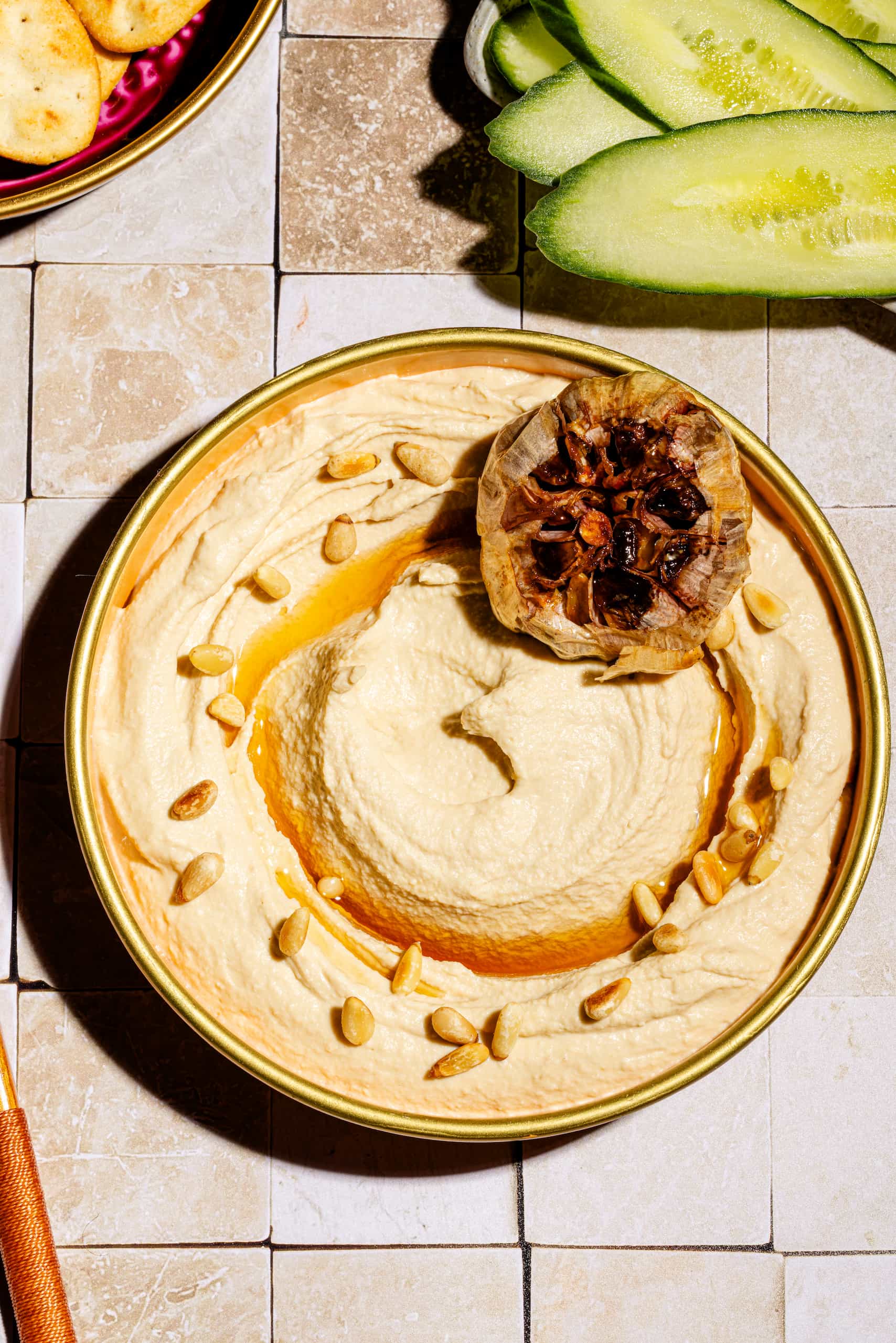 Houmous à l'ail rôti maison crémeux servi avec huile d'olive et pignons grillés