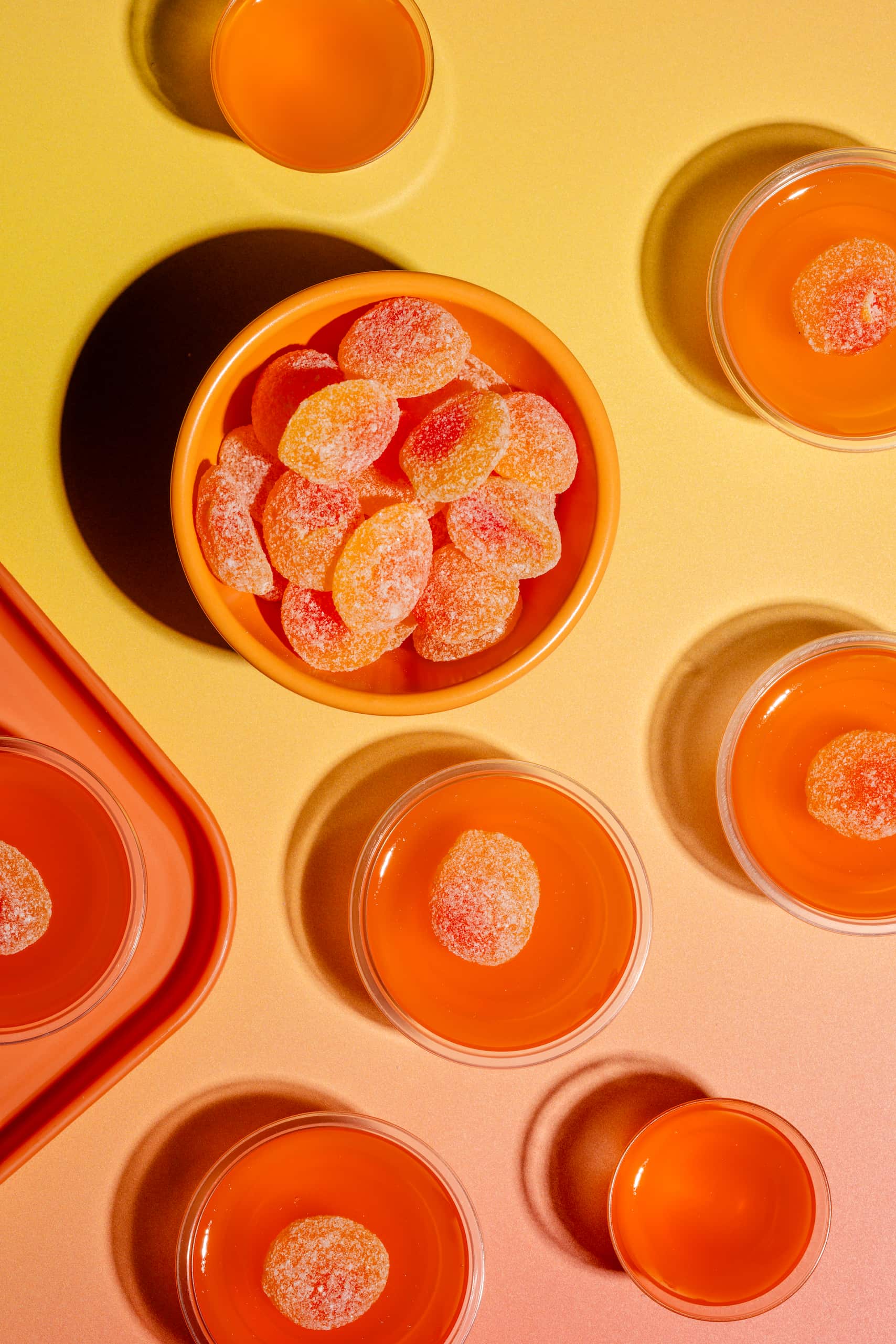 Shots gélifiés à la pêche servis dans des verres à shooter avec bonbons