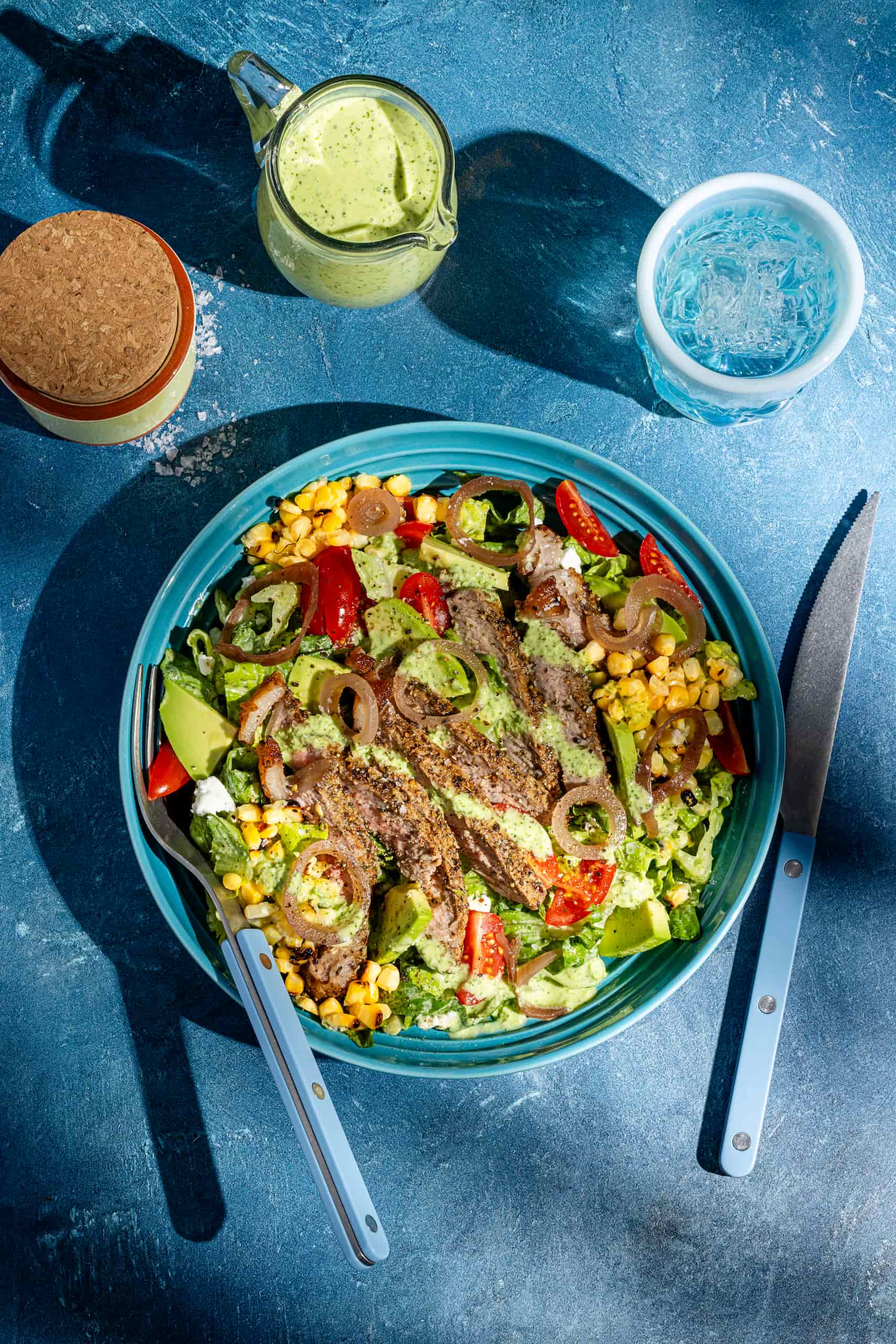 Salade de steak à l'avocat avec vinaigrette aux herbes servie dans un bol estival