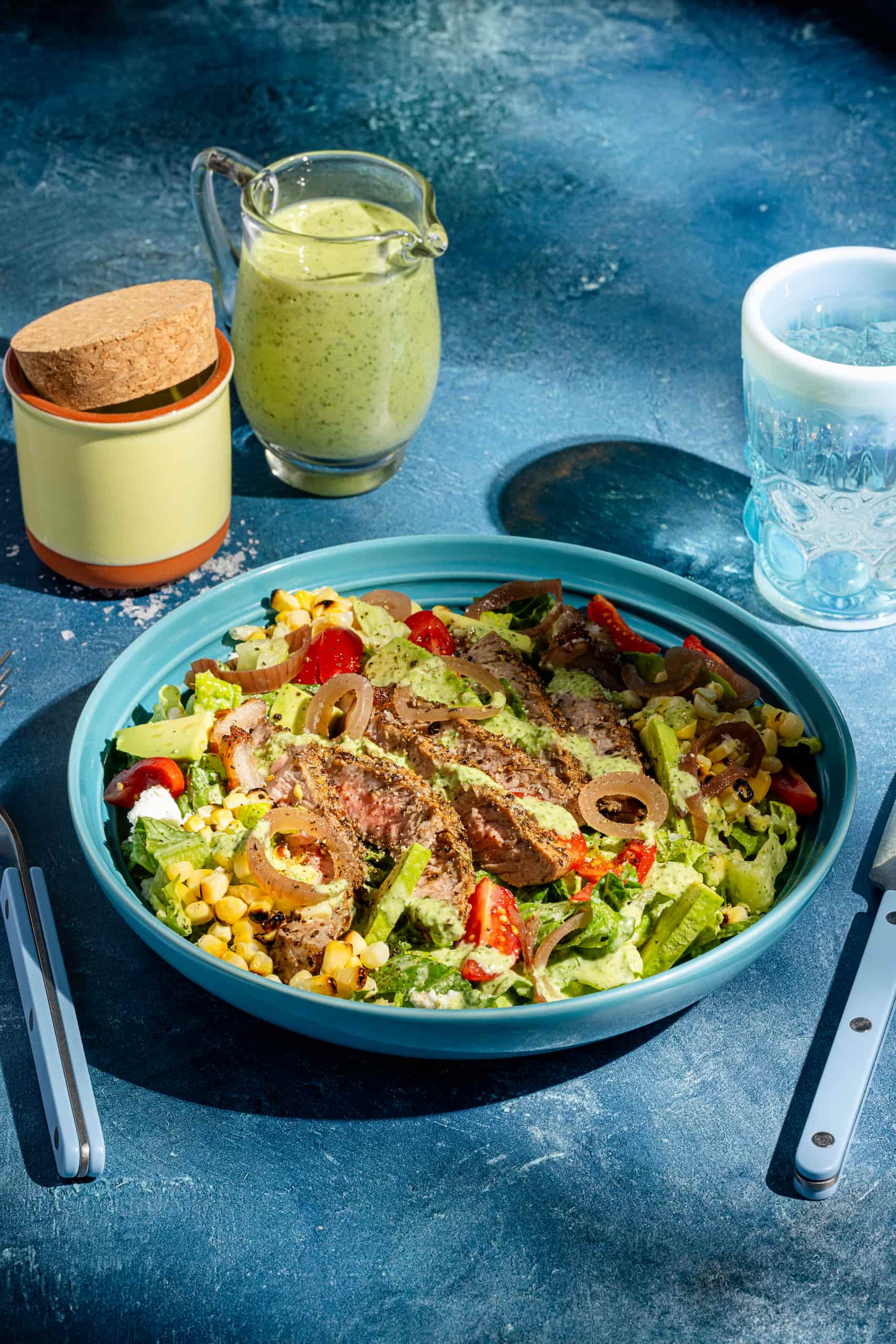 Salade de steak à l'avocat avec vinaigrette aux herbes servie dans un bol estival