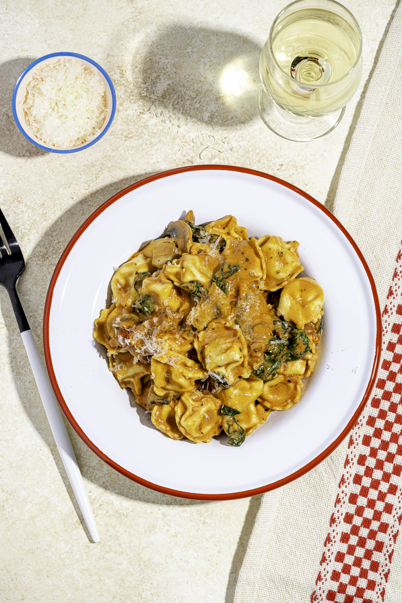 Tortellinis sauce rosée crémeux aux tomates séchées, champignons et parmesan dans une assiette
