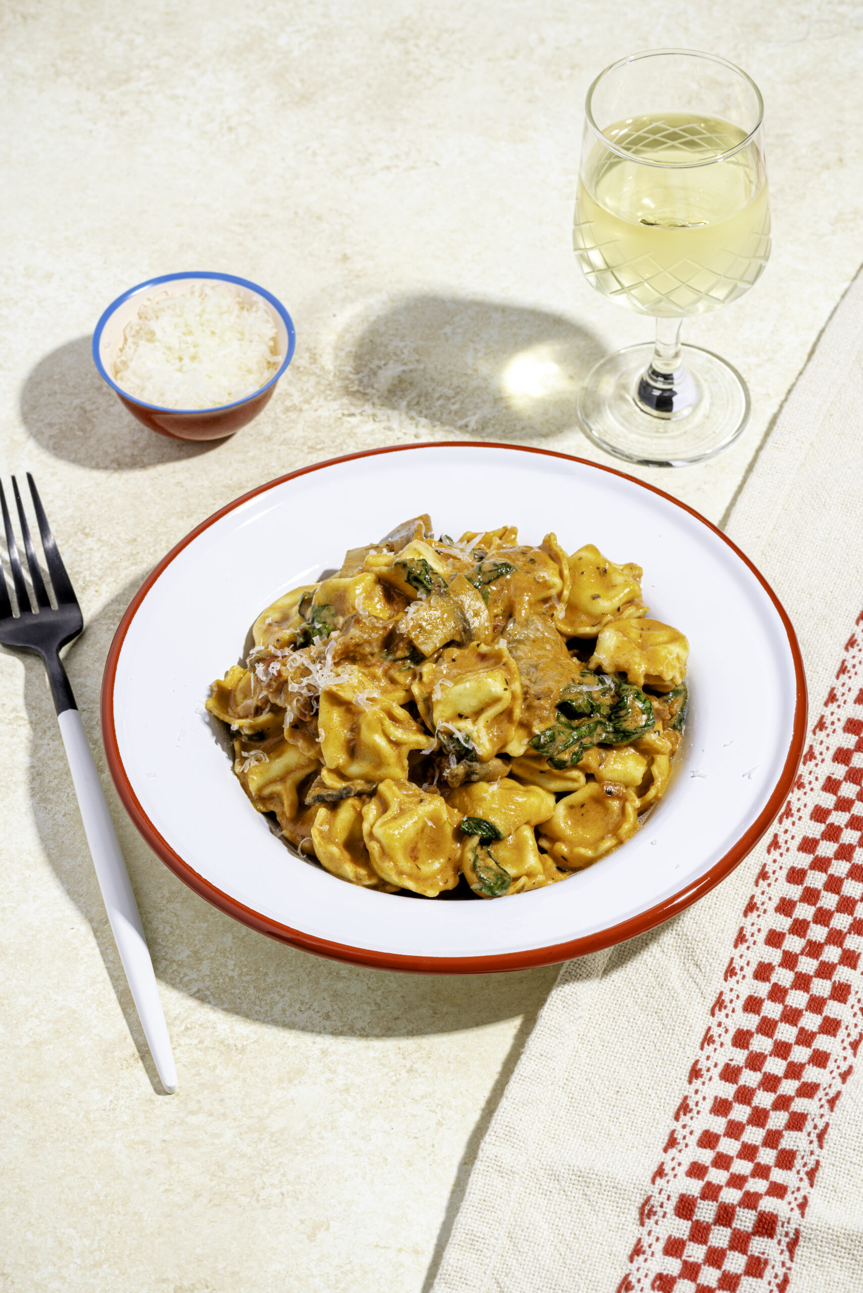 Tortellinis sauce rosée crémeux aux tomates séchées, champignons et parmesan dans une assiette