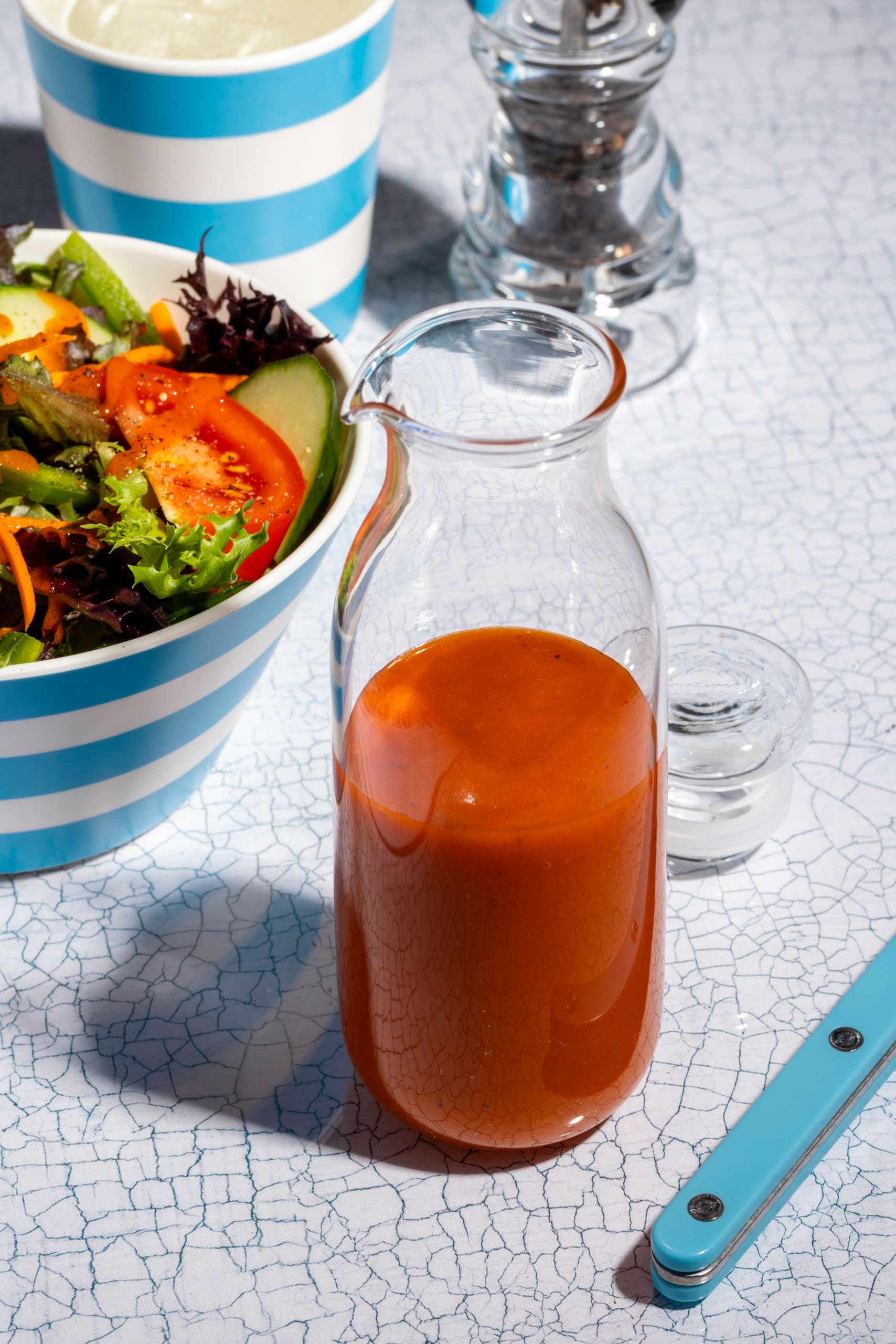 Vinaigrette Catalina maison rouge versée sur une salade verte fraîche et colorée