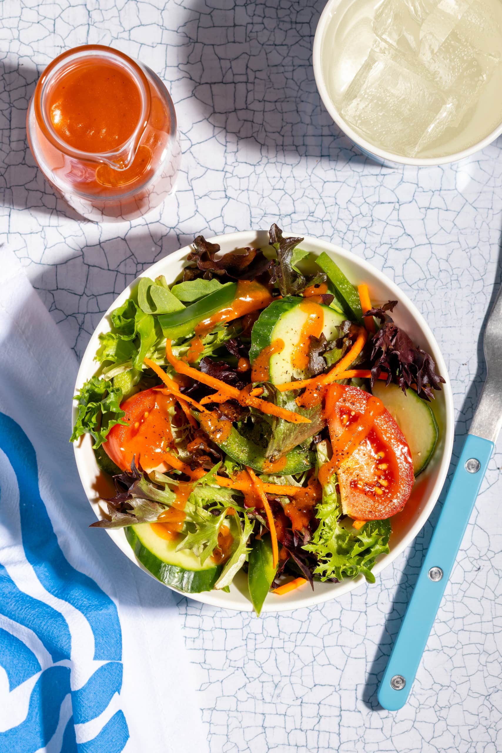 Vinaigrette Catalina maison rouge versée sur une salade verte fraîche et colorée