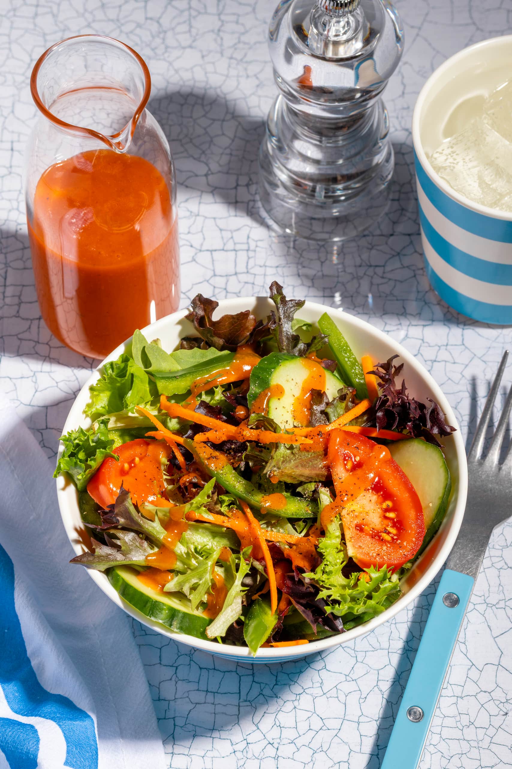 Vinaigrette Catalina maison rouge versée sur une salade verte fraîche et colorée