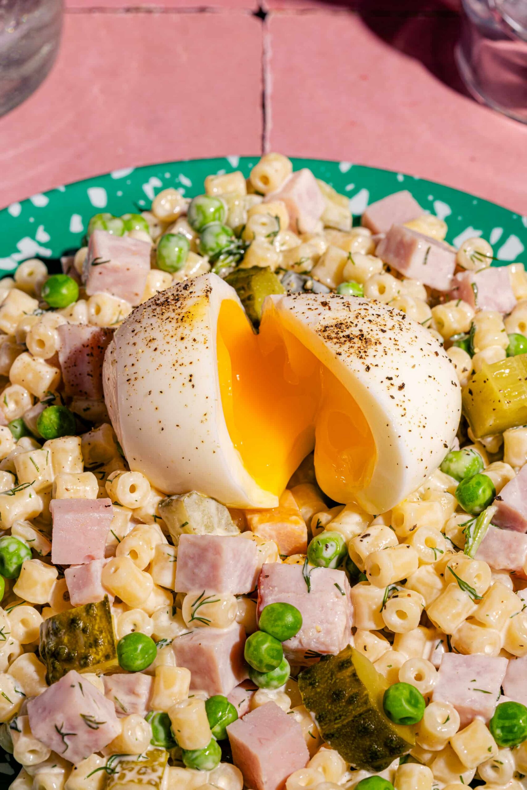 Salade froide de pâtes en anneaux avec jambon, cornichons et oeufs mollets