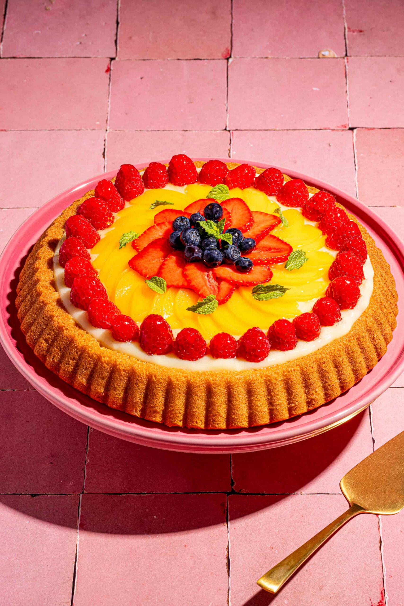 Tarte éponge individuelle garnie de crème pâtissière et de fruits frais colorés