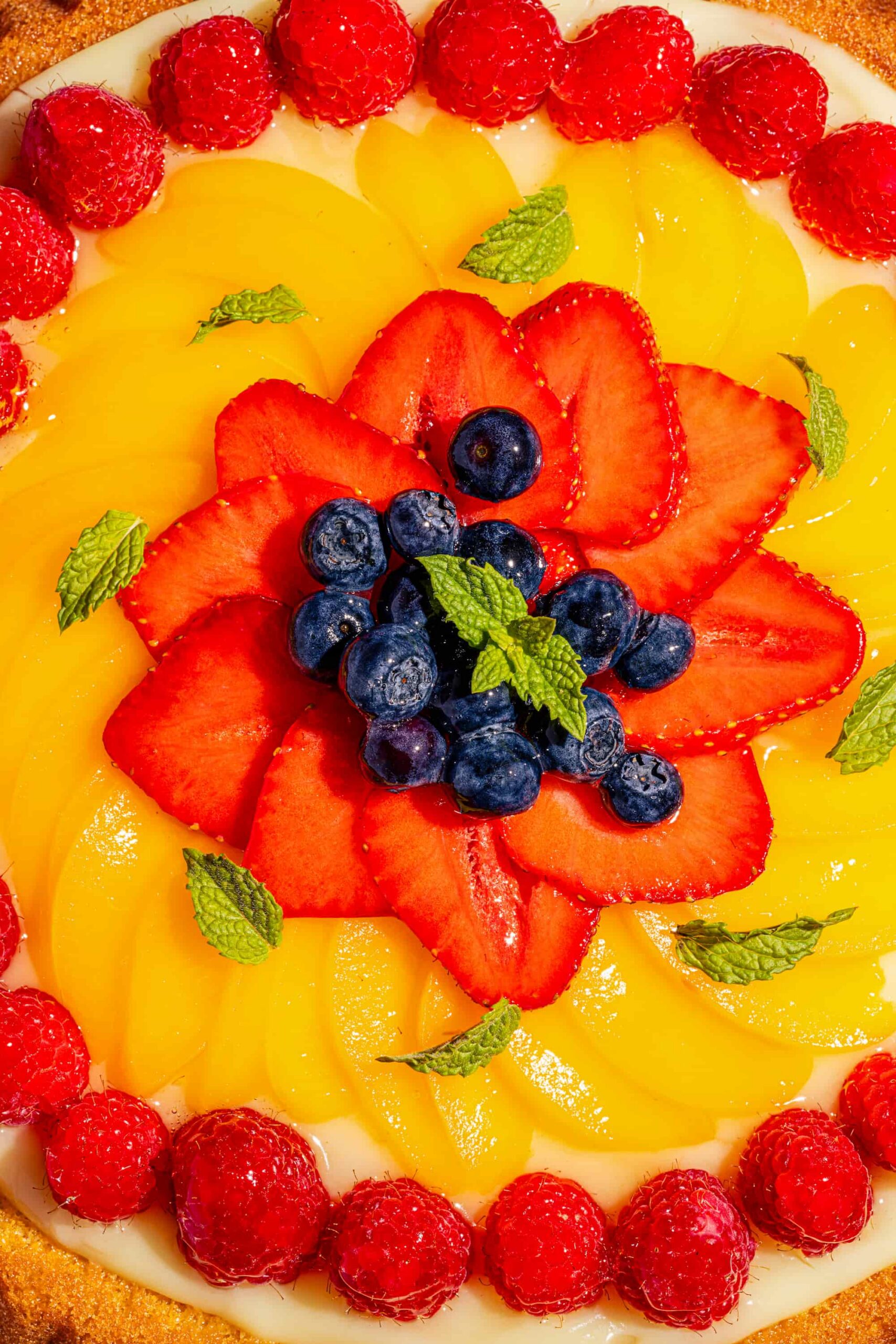 Tarte éponge individuelle garnie de crème pâtissière et de fruits frais colorés