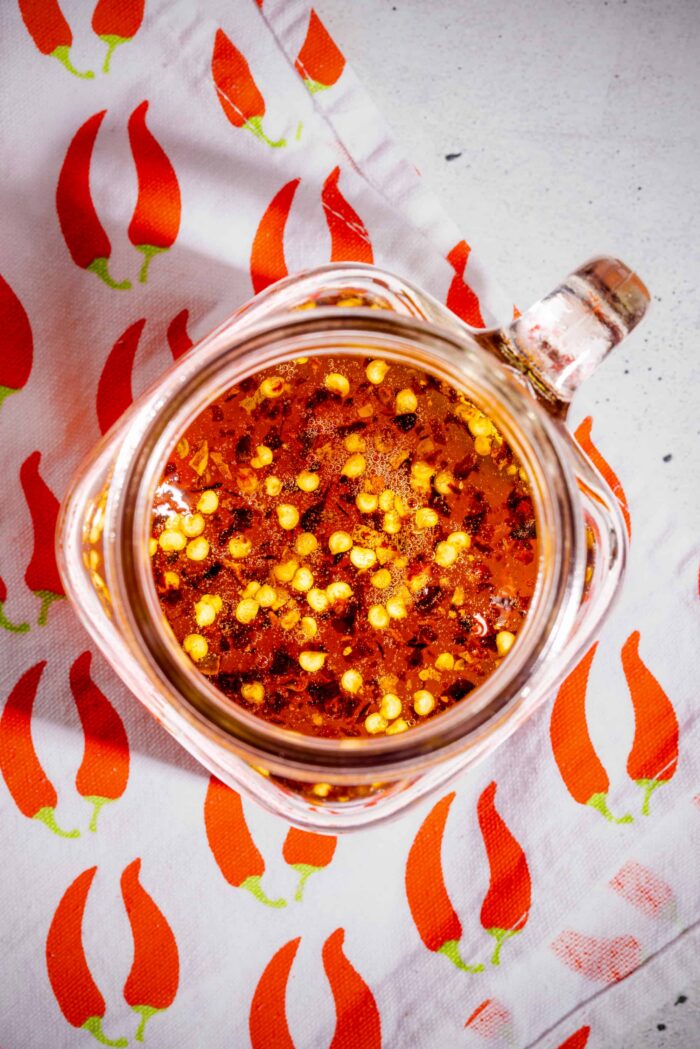 Miel épicé maison servi dans un pot en verre avec flocons de piment visibles