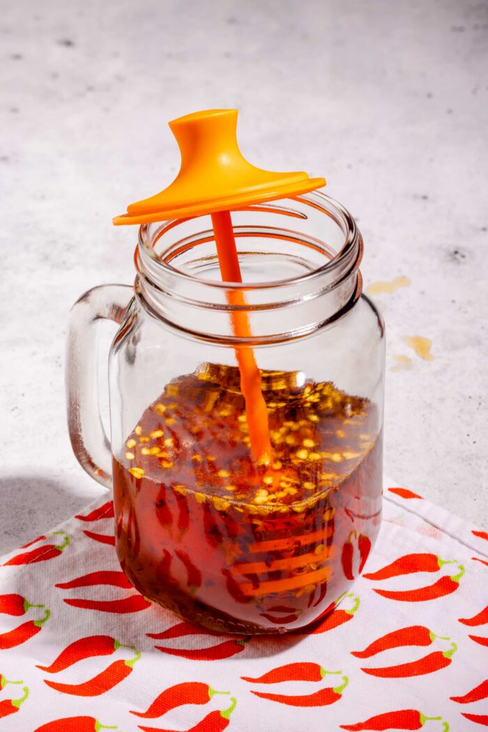 Miel épicé maison servi dans un pot en verre avec flocons de piment visibles