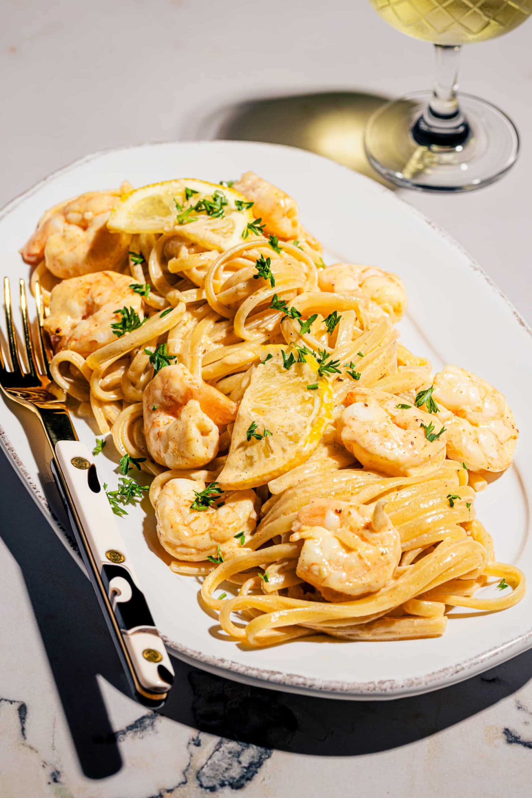 Linguines crémeuses aux crevettes et au parmesan garnies de persil frais dans une assiette