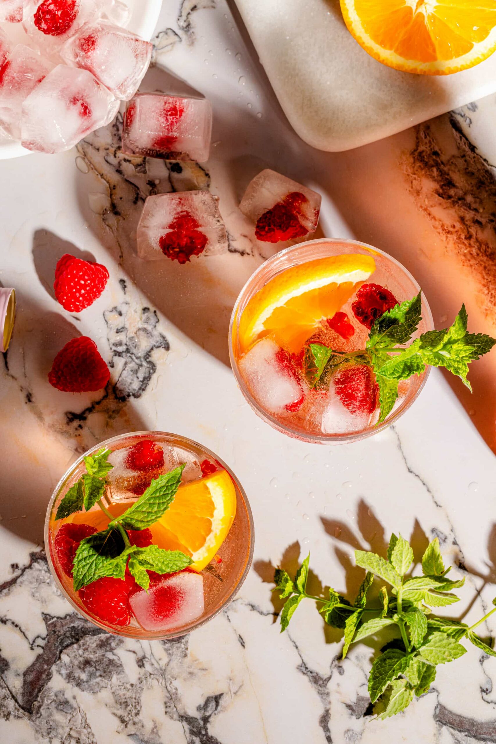 Sangria rosée aux framboises fraîches servie avec glaçons et menthe