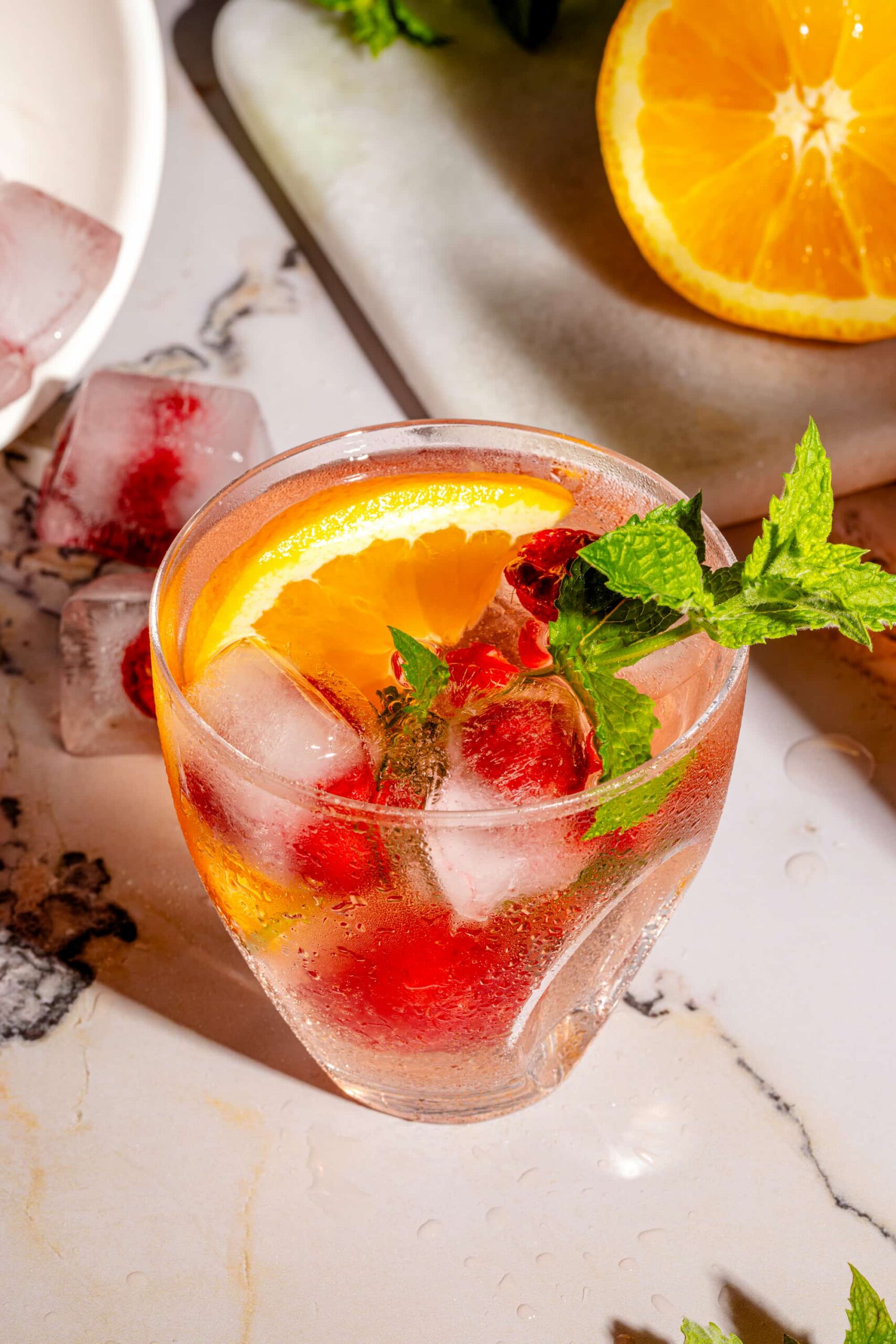 Sangria rosée aux framboises fraîches servie avec glaçons et menthe