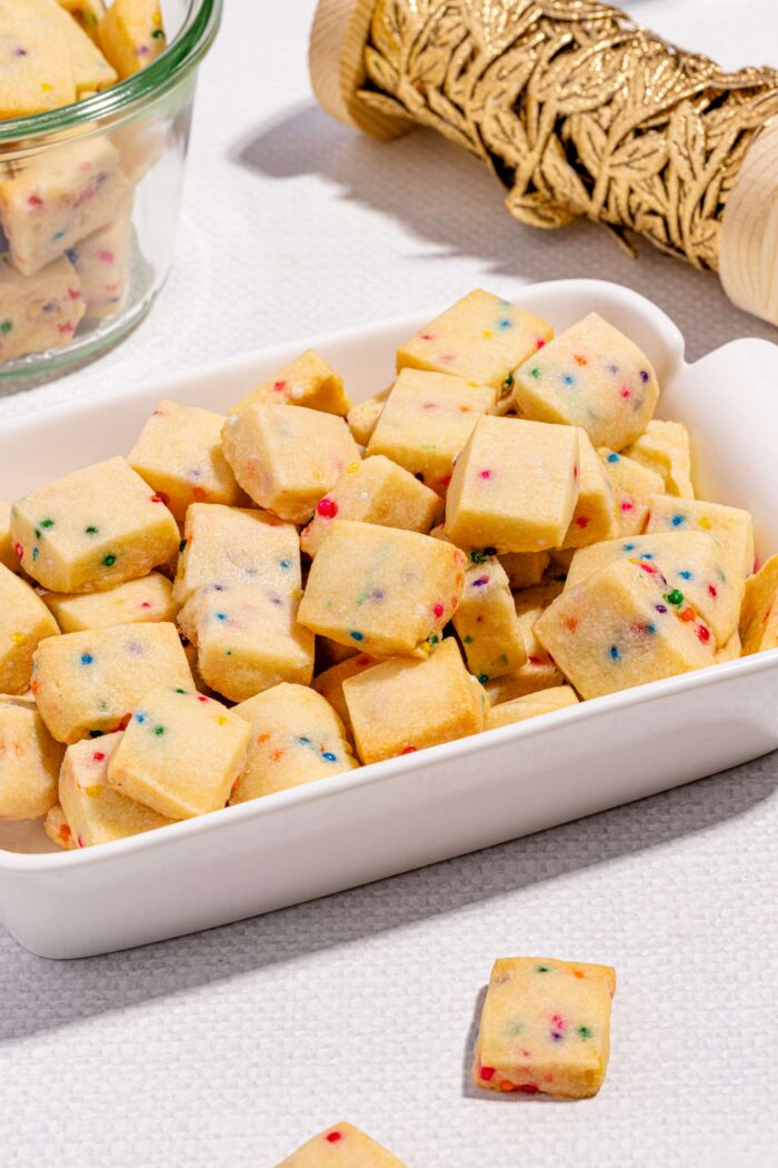 Bouchées de biscuits sablés de Noël aux confettis arc-en-ciel dans un bol festif