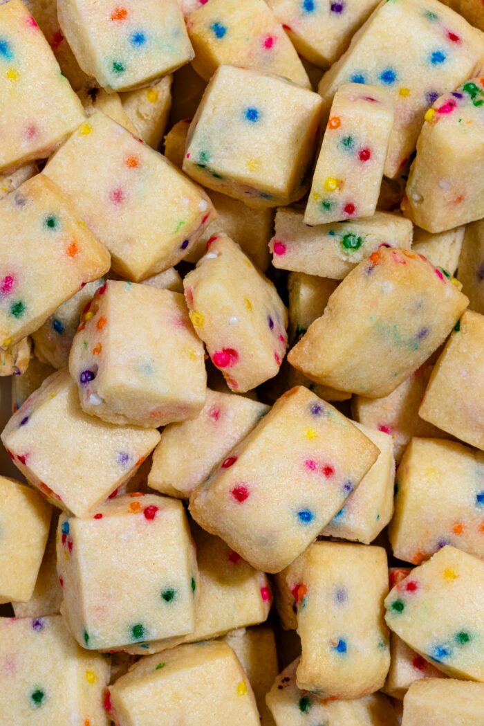 Bouchées de biscuits sablés de Noël aux confettis arc-en-ciel dans un bol festif