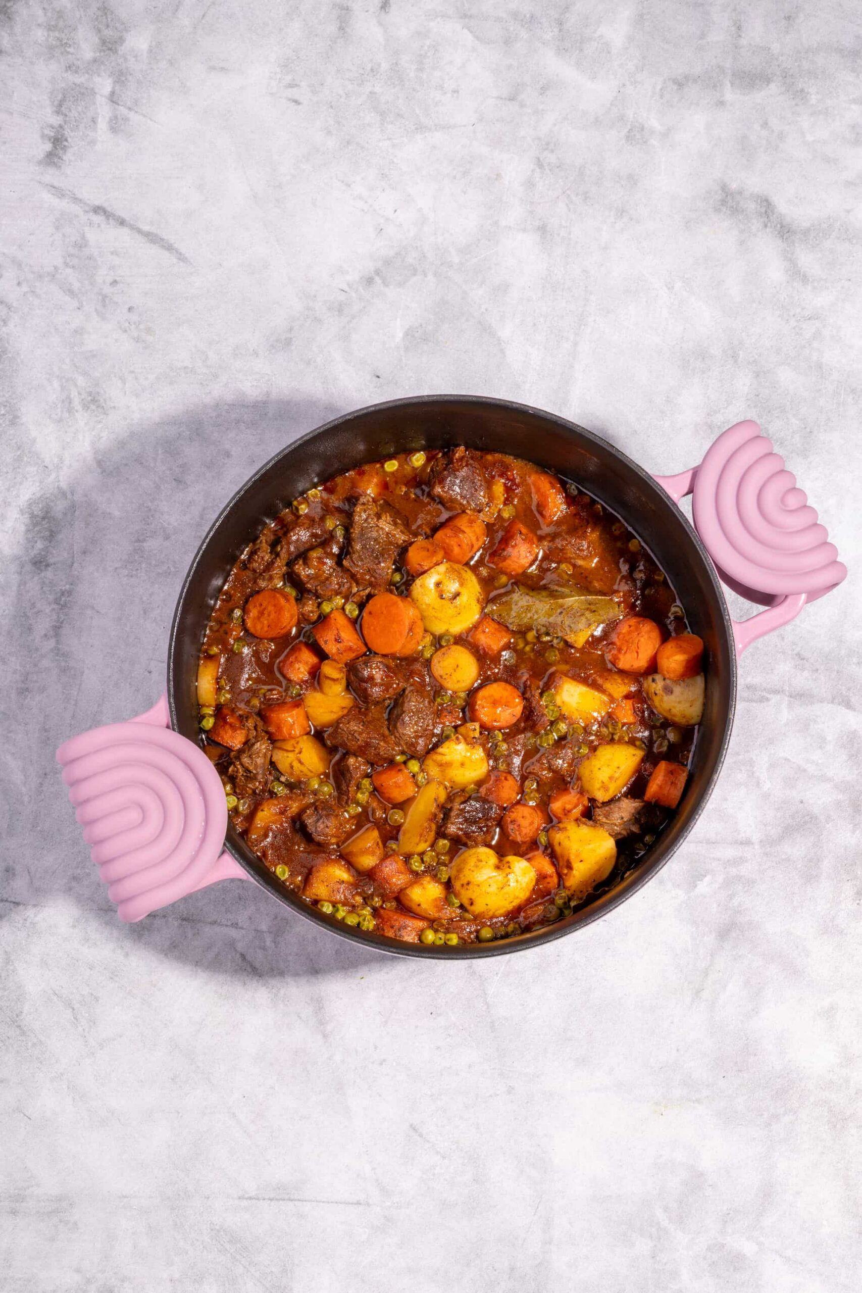 Bouilli de boeuf tomaté aux légumes racines servi bien chaud dans une cocotte