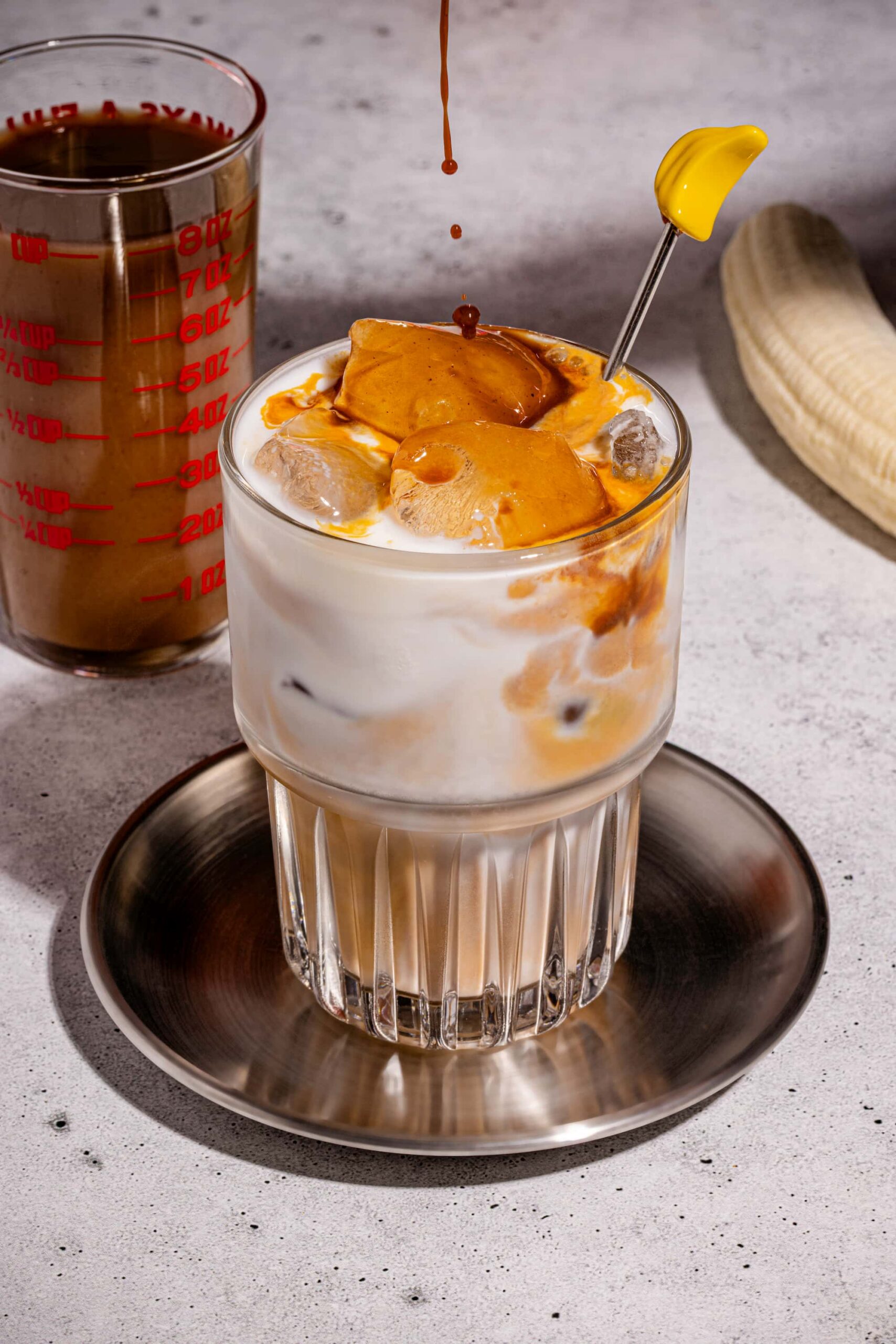 Latte glacé au pain aux bananes servi dans un grand verre avec espresso et glaçons