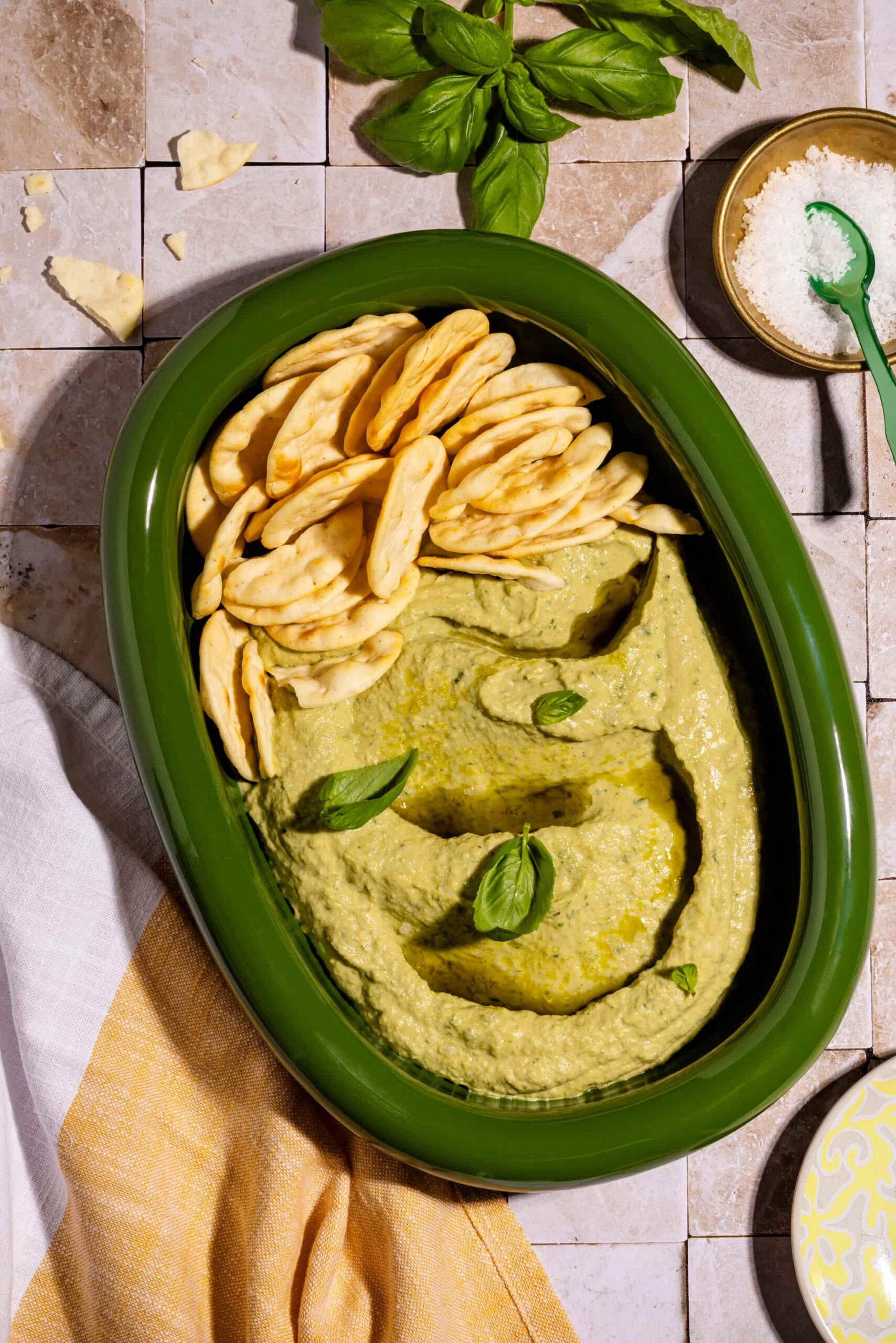 Houmous au basilic ultra crémeux servi dans un bol avec huile d'olive et pita