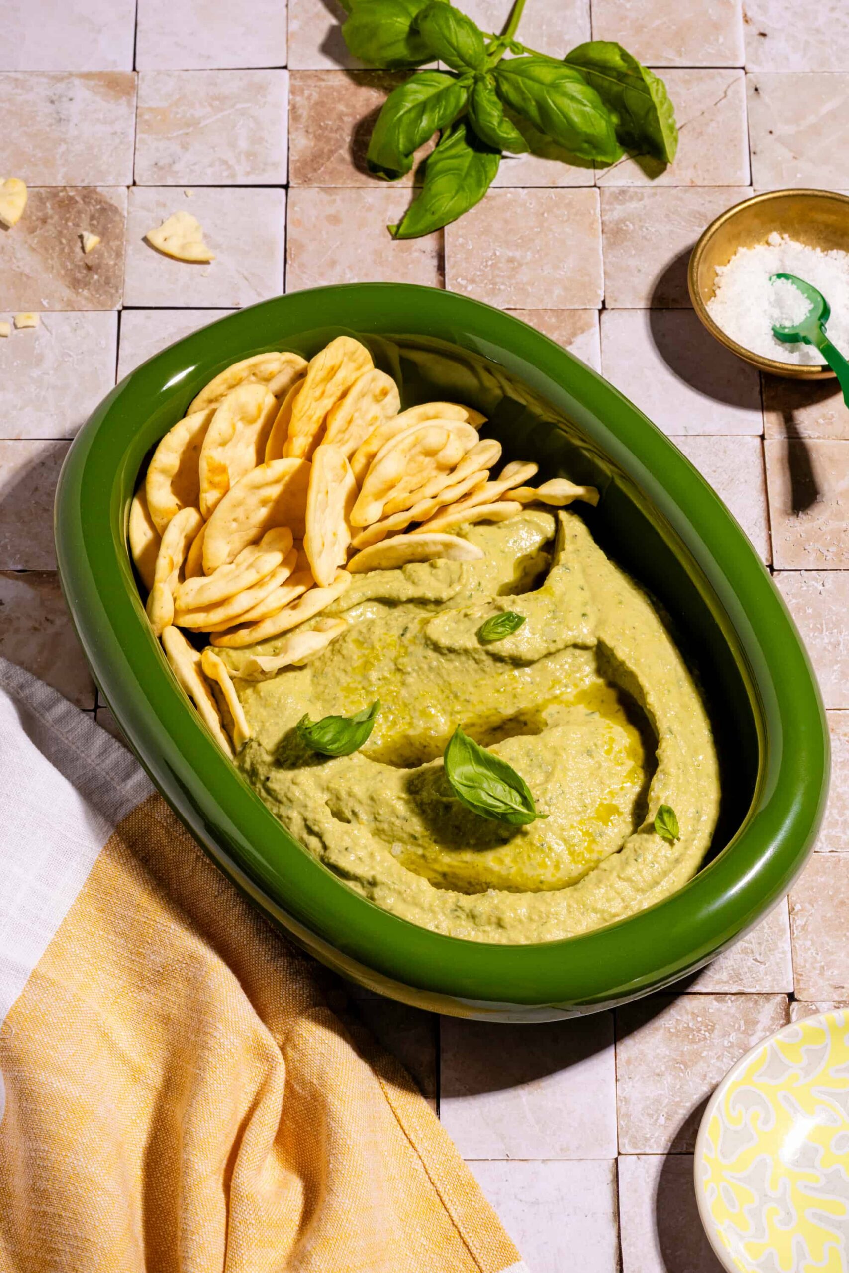 Houmous au basilic ultra crémeux servi dans un bol avec huile d'olive et pita