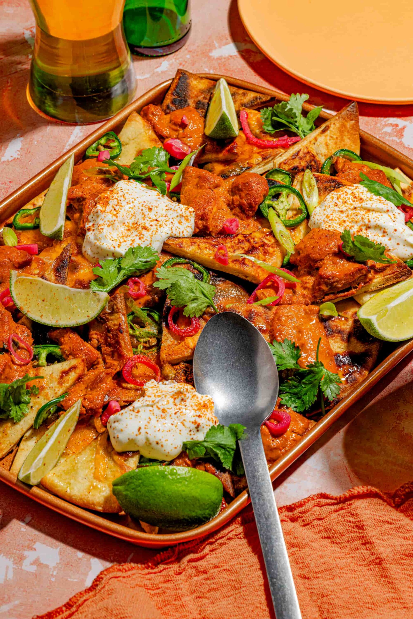 Nachos au poulet au beurre sur pains naan garnis de cheddar fondant et coriandre fraîche