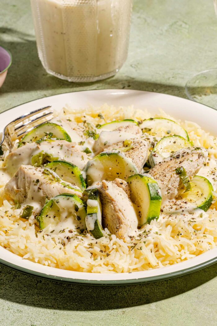 Poulet et courgettes avec sauce crémeuse à l'ail servis sur un lit de riz