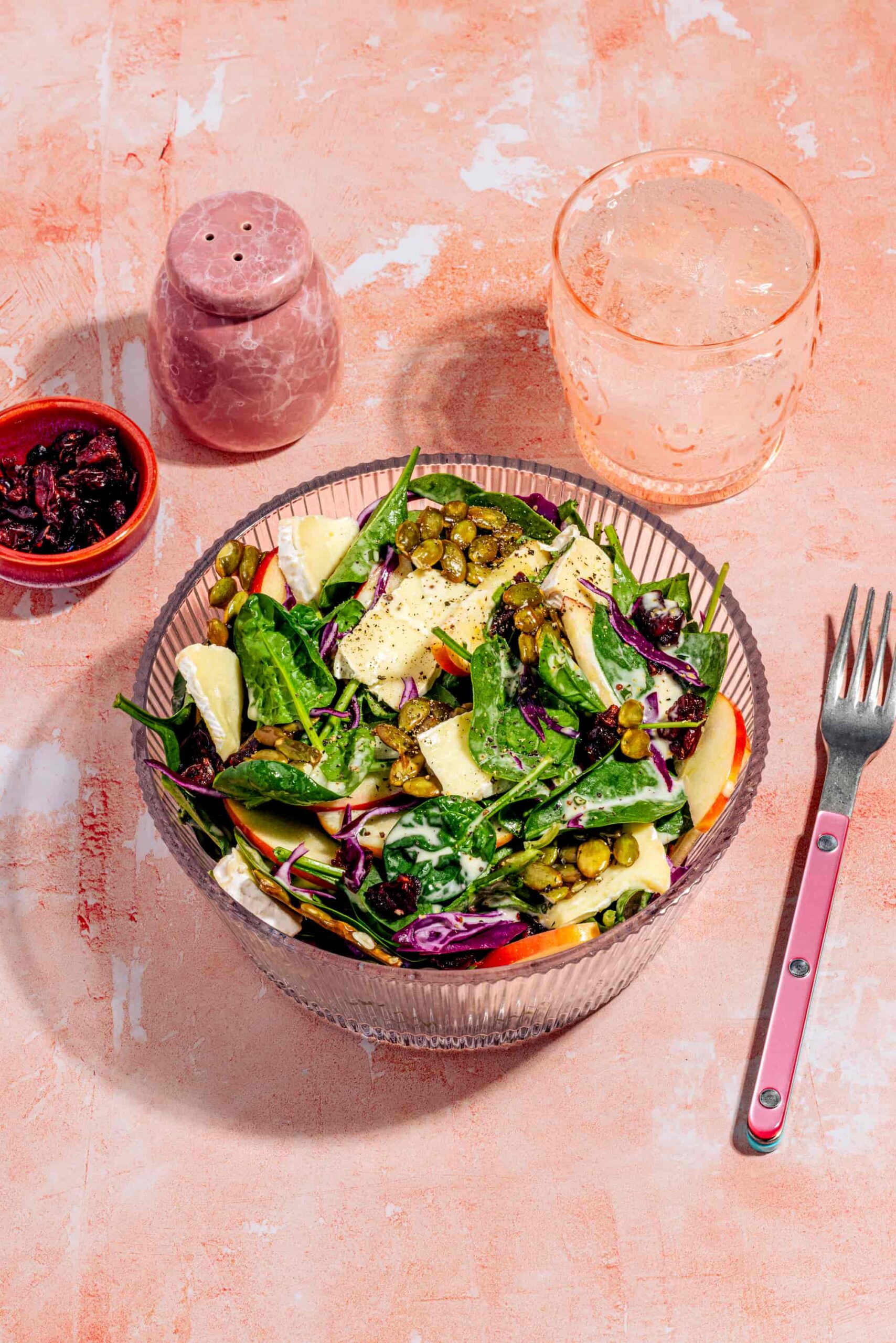 Salade d'épinards aux pommes avec brie, canneberges et graines de citrouille caramélisées