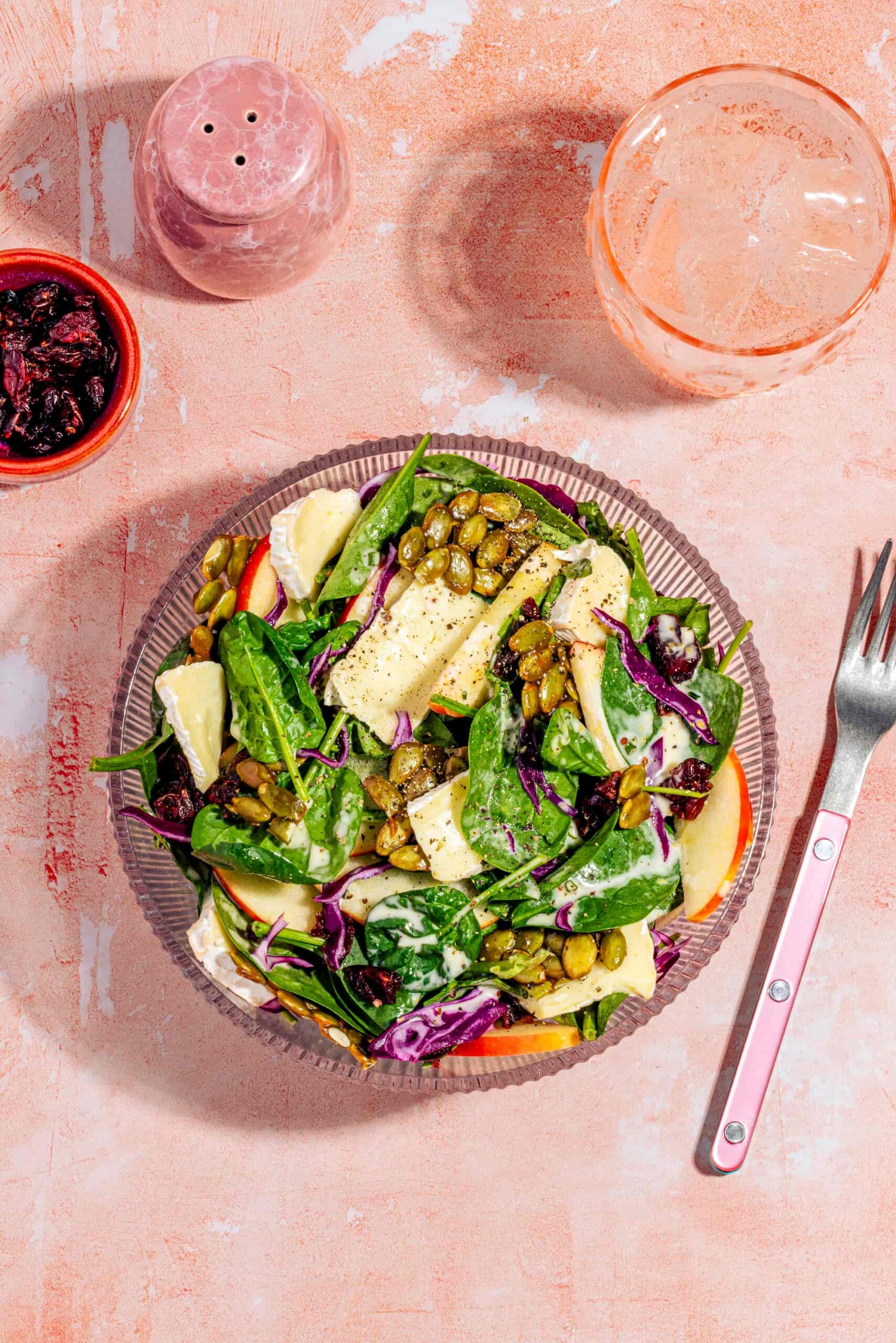 Salade d'épinards aux pommes avec brie, canneberges et graines de citrouille caramélisées